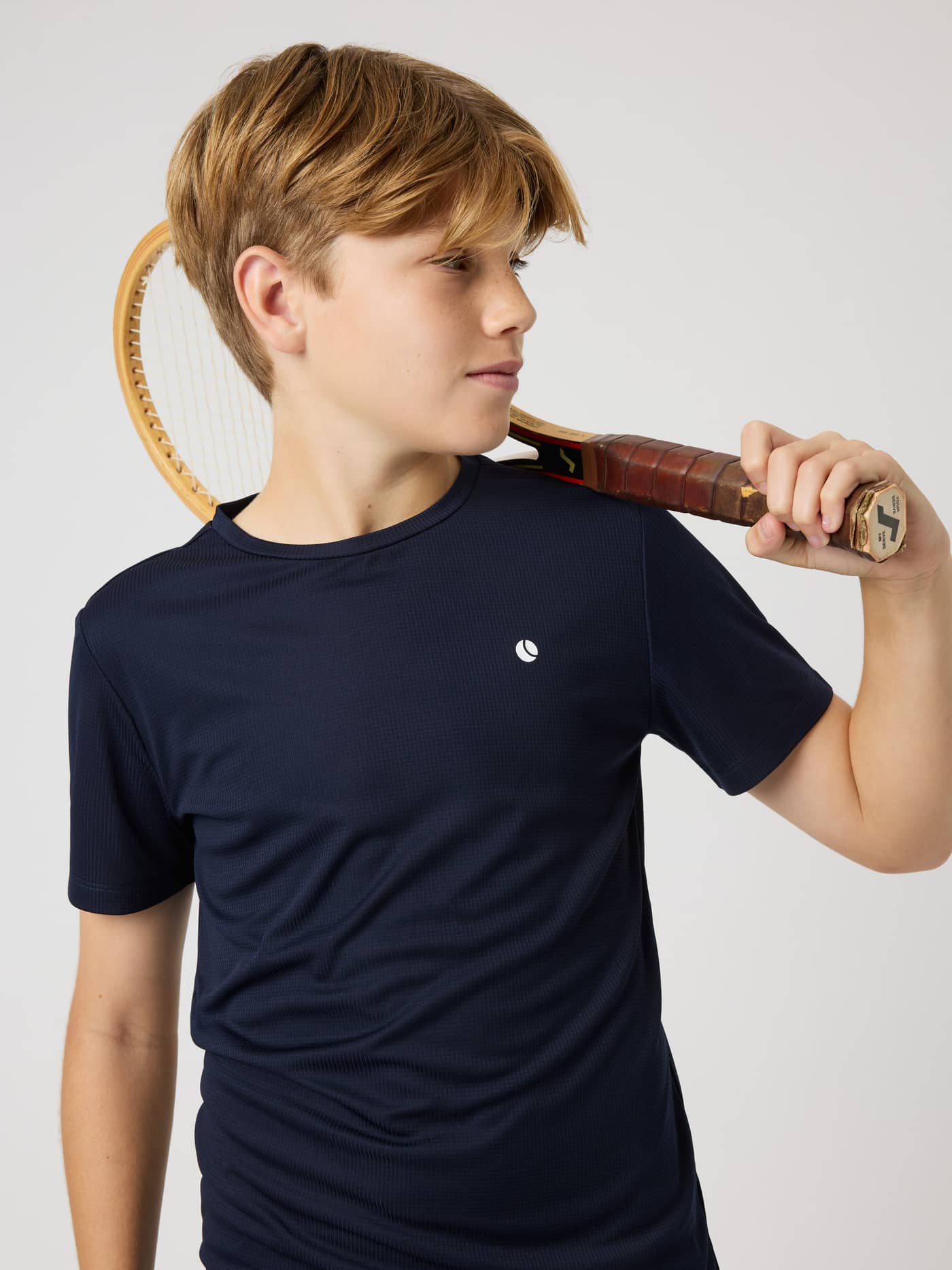 Front view of kids wearing the Ace Light T-Shirt in Night sky (Navy) with a tennis racket for on-court performance. - Image 4