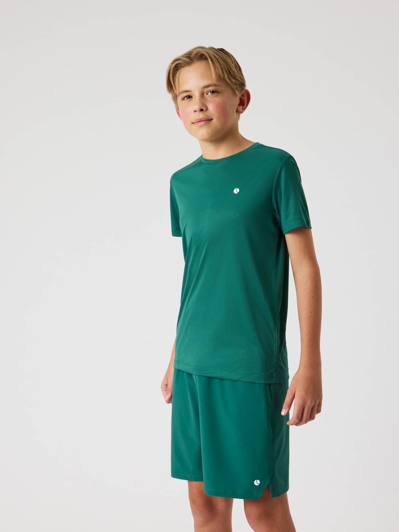 Framifrån på en pojke i Björn Borg Ace Light T-Shirt i Posy Green (Grön), en funktionell tenniströja för kids. - Image 5