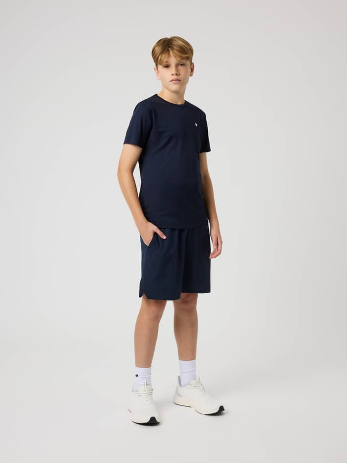 Full-body front view of a kid wearing Ace Racquet Shorts in Night Sky (Navy), designed for tennis and performance.
