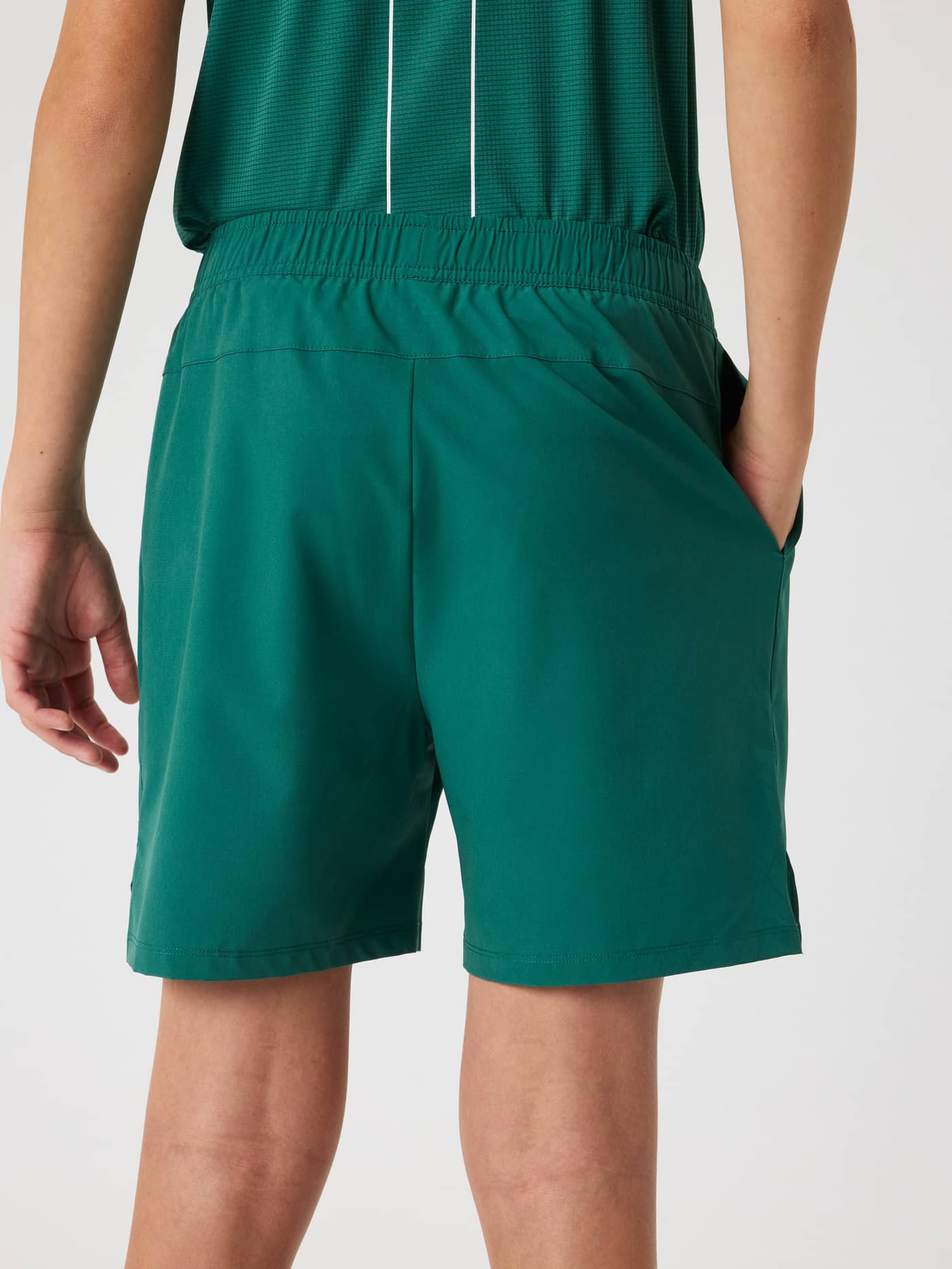 Vista posterior de un niño con los Ace Racquet Shorts en Posy Green (Verde) para un alto rendimiento en tenis. - Image 3