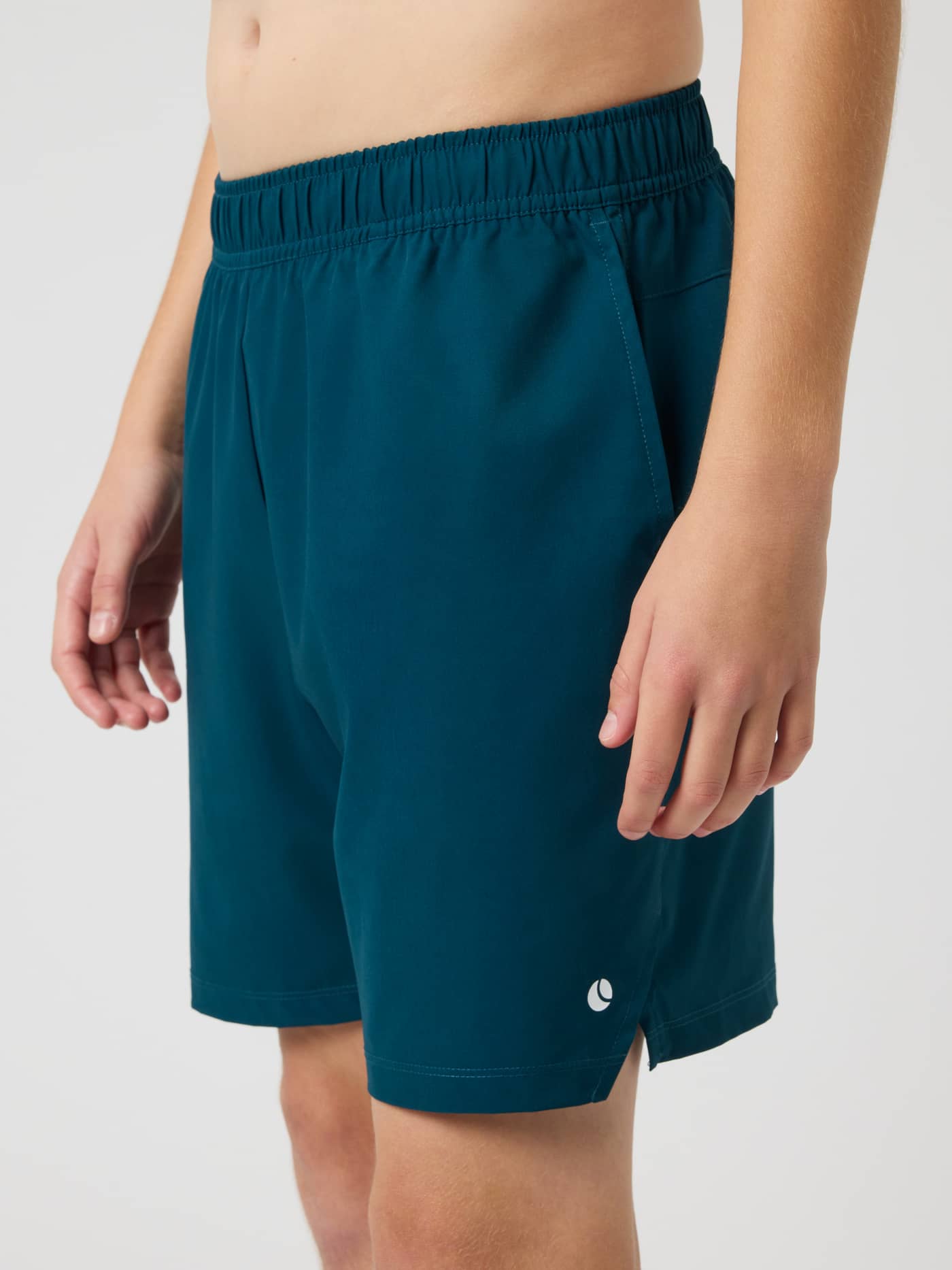Ace Racquet Shorts in Reflecting Pond (Green) for kids, featuring a white ball logo and side slits for mobility in tennis. - Image 2