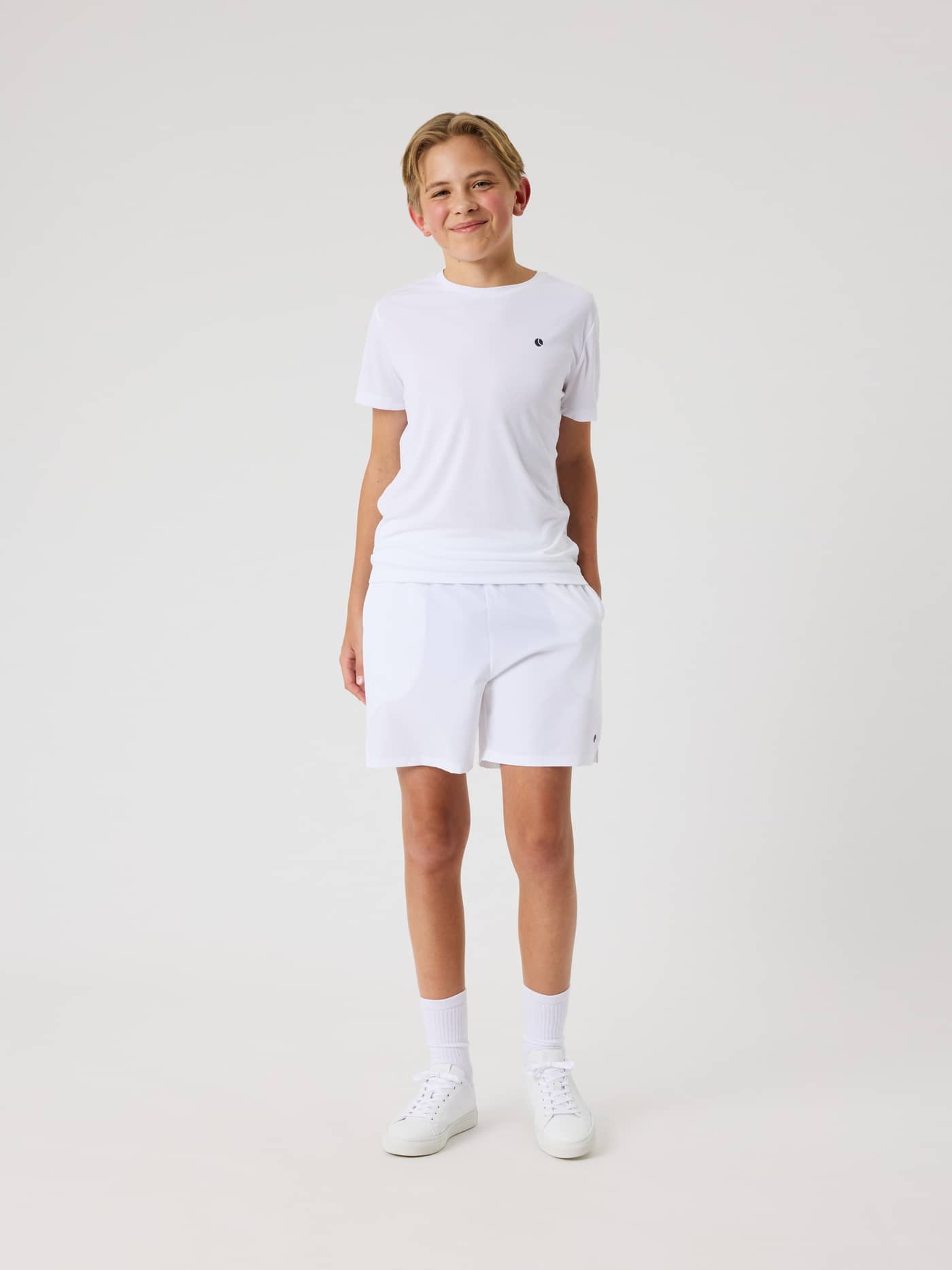 Full-body front view of a kid wearing the Björn Borg Ace Racquet Shorts in Brilliant White (White) for kids' tennis. - Image 3