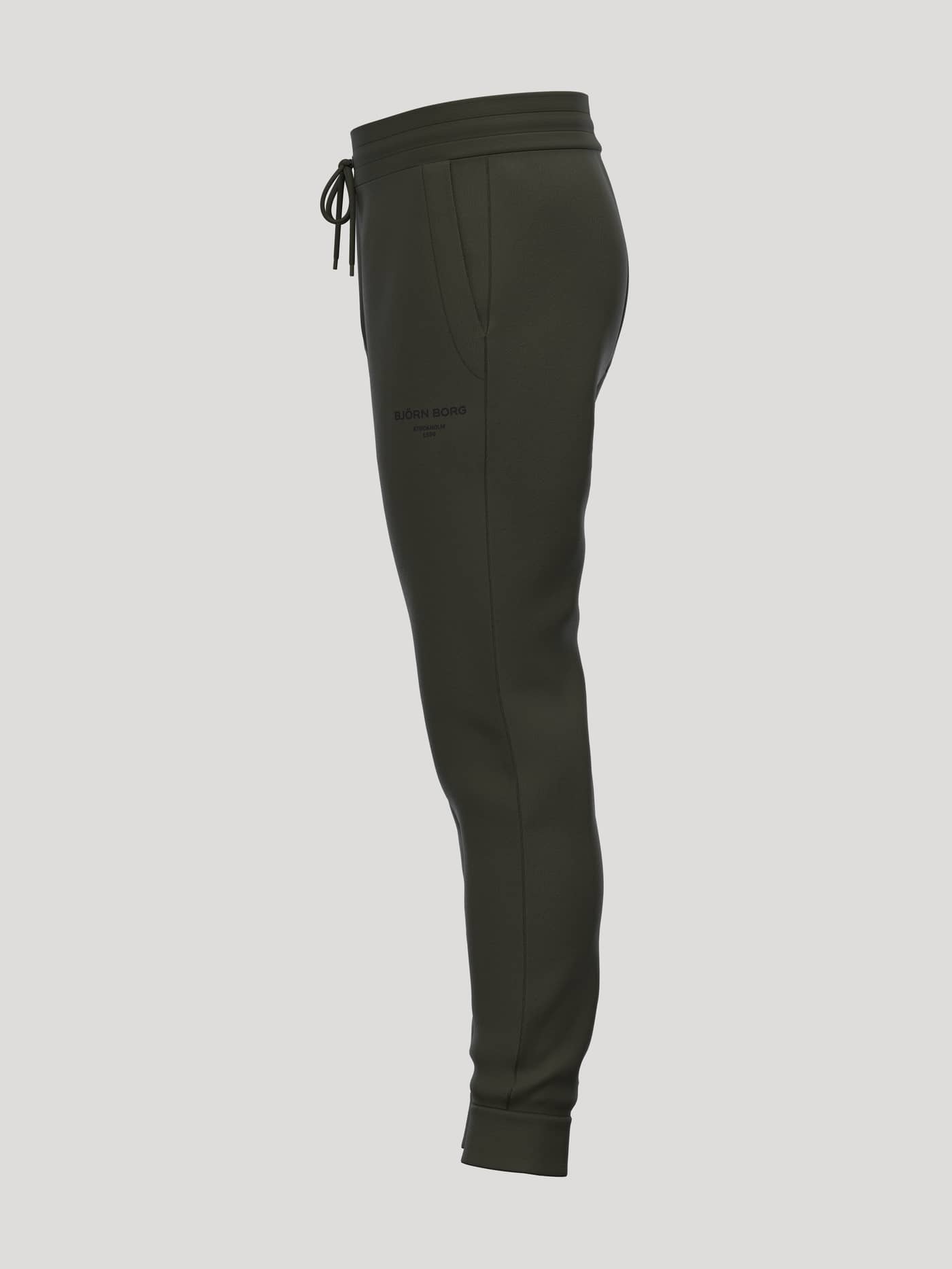 Side view of Borg Essential 1 Tapered Sweatpants in Rosin (Green) with tapered legs and black logo for a tennis style. - Image 3