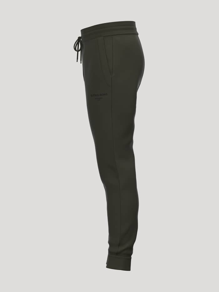 Zijaanzicht van de Borg Essential 1 Tapered Sweatpants in Rosin (Groen) met taps toelopende pijpen en zwart logo voor tennis. - Image 3