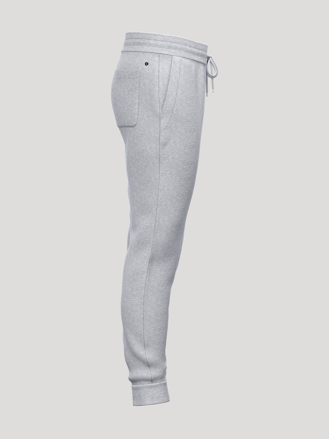 Borg Essential 1 Tapered Sweatpants in Light Grey Melange (Grey) shown in a side profile with a tennis ball graphic. - Image 4