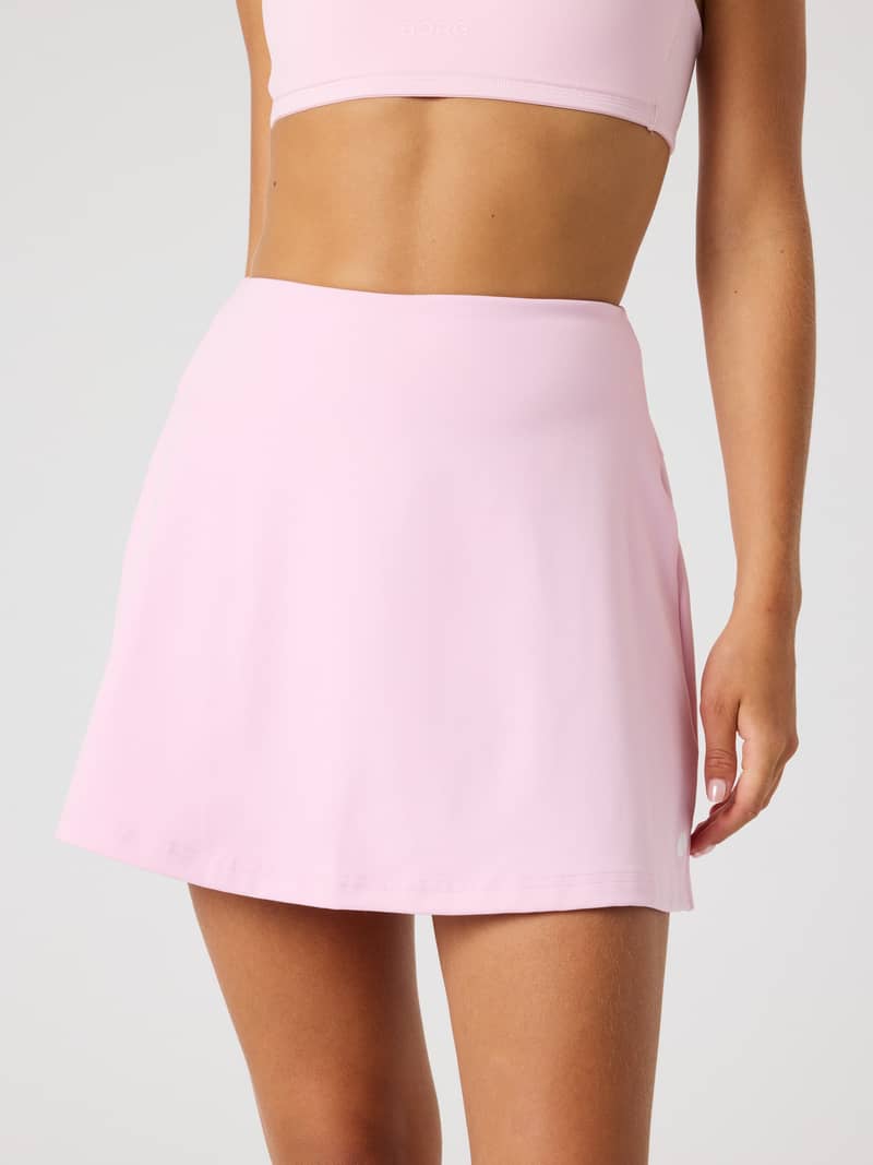 Vue de face de la Ace Stretch Skirt à taille haute en Pink Lady (Rose), un modèle de performance pour le tennis.