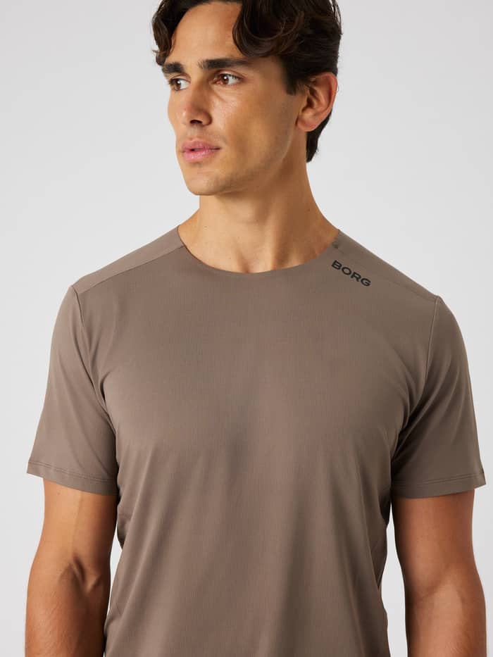 Vooraanzicht van een man in het Björn Borg Feather T-Shirt in Falcon (Bruin) voor training met een zwart logo. - Image 5