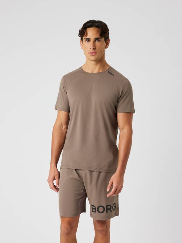 Vue de face d'un homme en Borg Feather T-Shirt Falcon (Marron), t-shirt d'entraînement léger au logo noir.