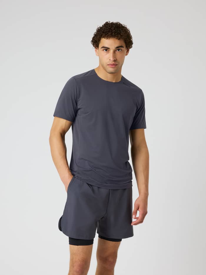 Front view of a man wearing the Borg Feather T-Shirt in Asphalt (Grey) with a black logo, for quick-dry training and tennis.