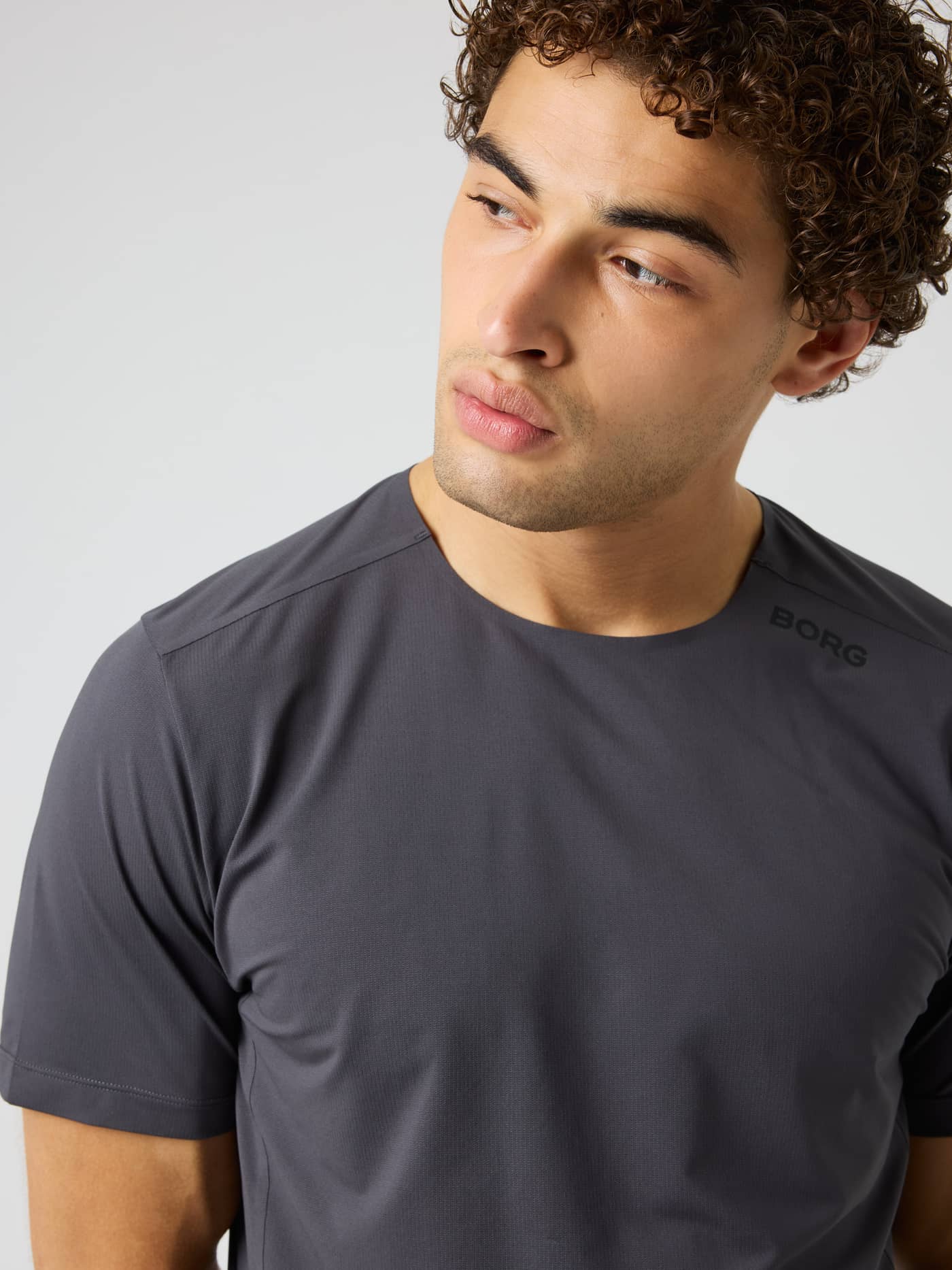 Close-up of the Borg Feather T-Shirt in Asphalt (Grey), featuring a black shoulder logo for tennis and training. - Image 4