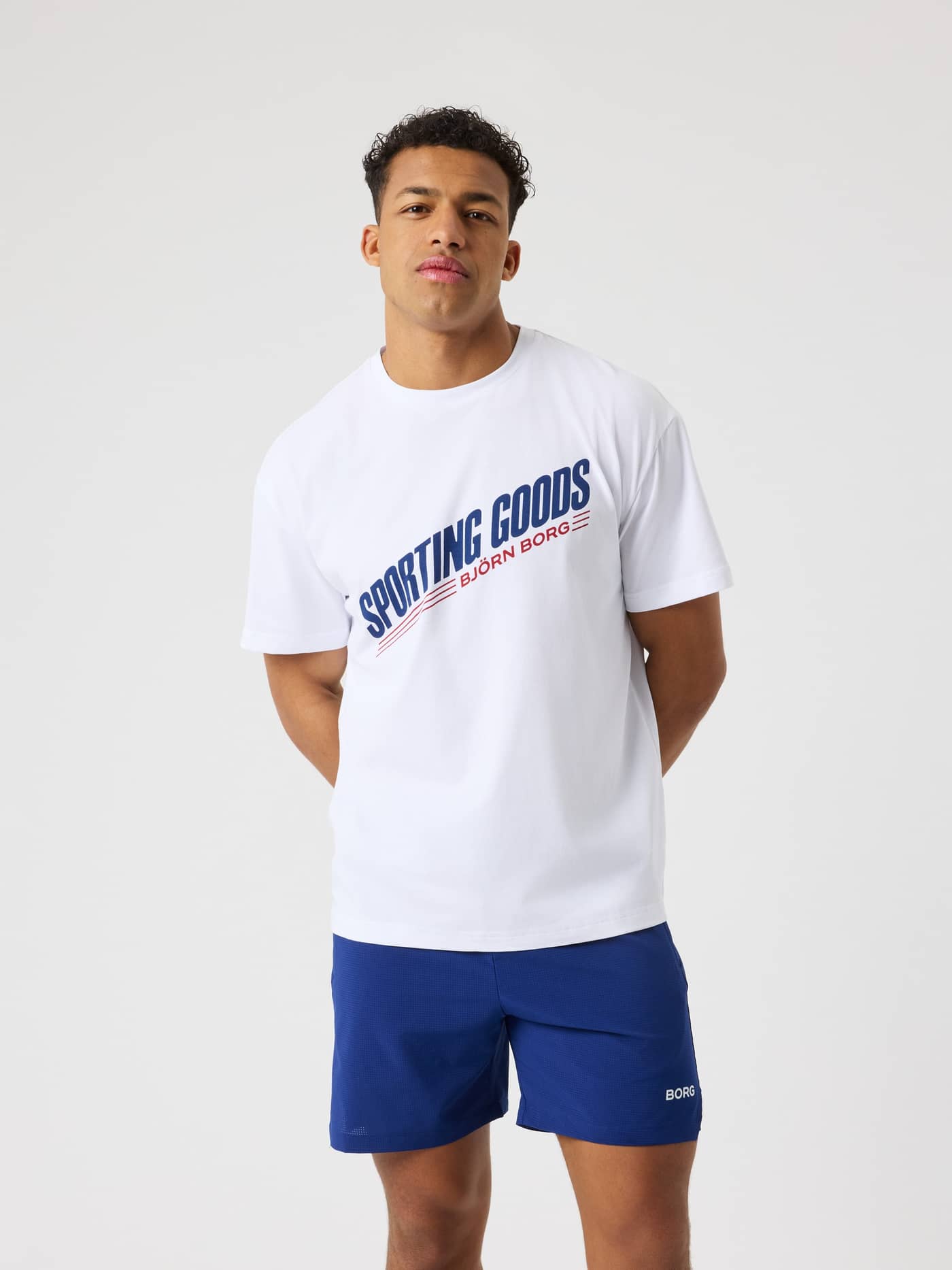Front view of a man in the cotton-blend Borg Gym Oversized T-Shirt in Brilliant White (White) with a training chest graphic. - Image 1
