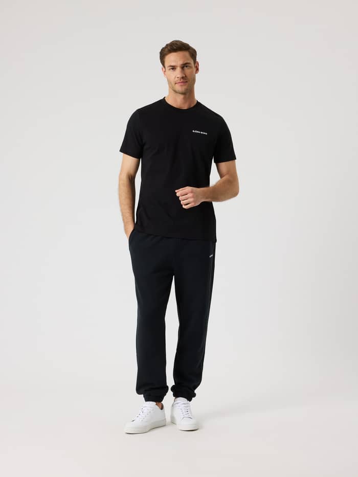 Vooraanzicht van een man in het Borg Sports T-Shirt van katoenmix in Black Beauty (Zwart) voor training en tennis. - Image 3