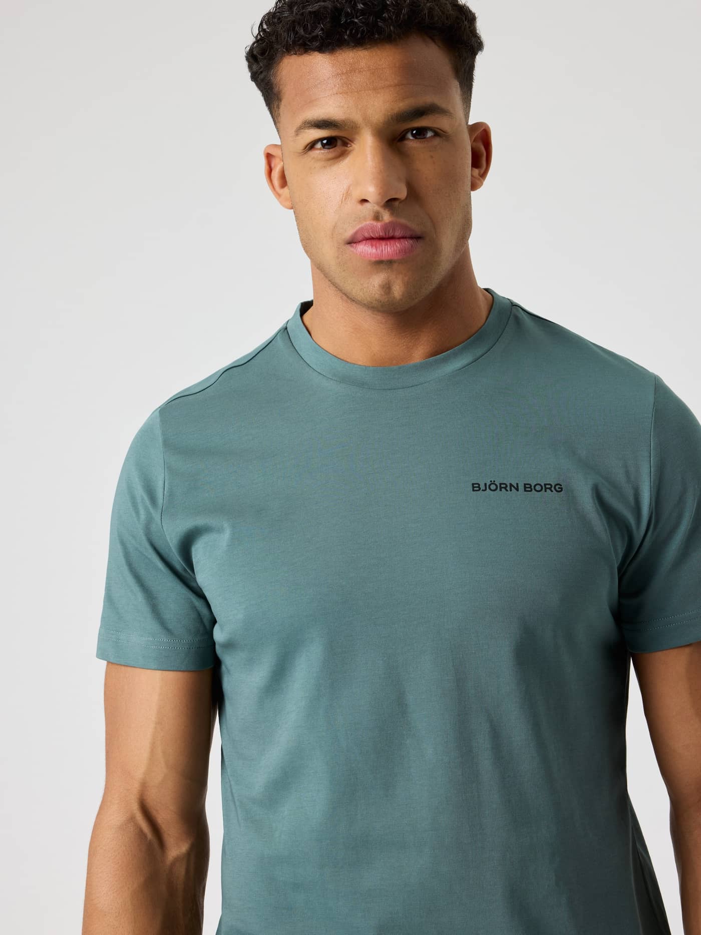 Borg Sports T-Shirt i Balsam Green (Grøn) set forfra med et sort logo til træning og tennis. - Image 4