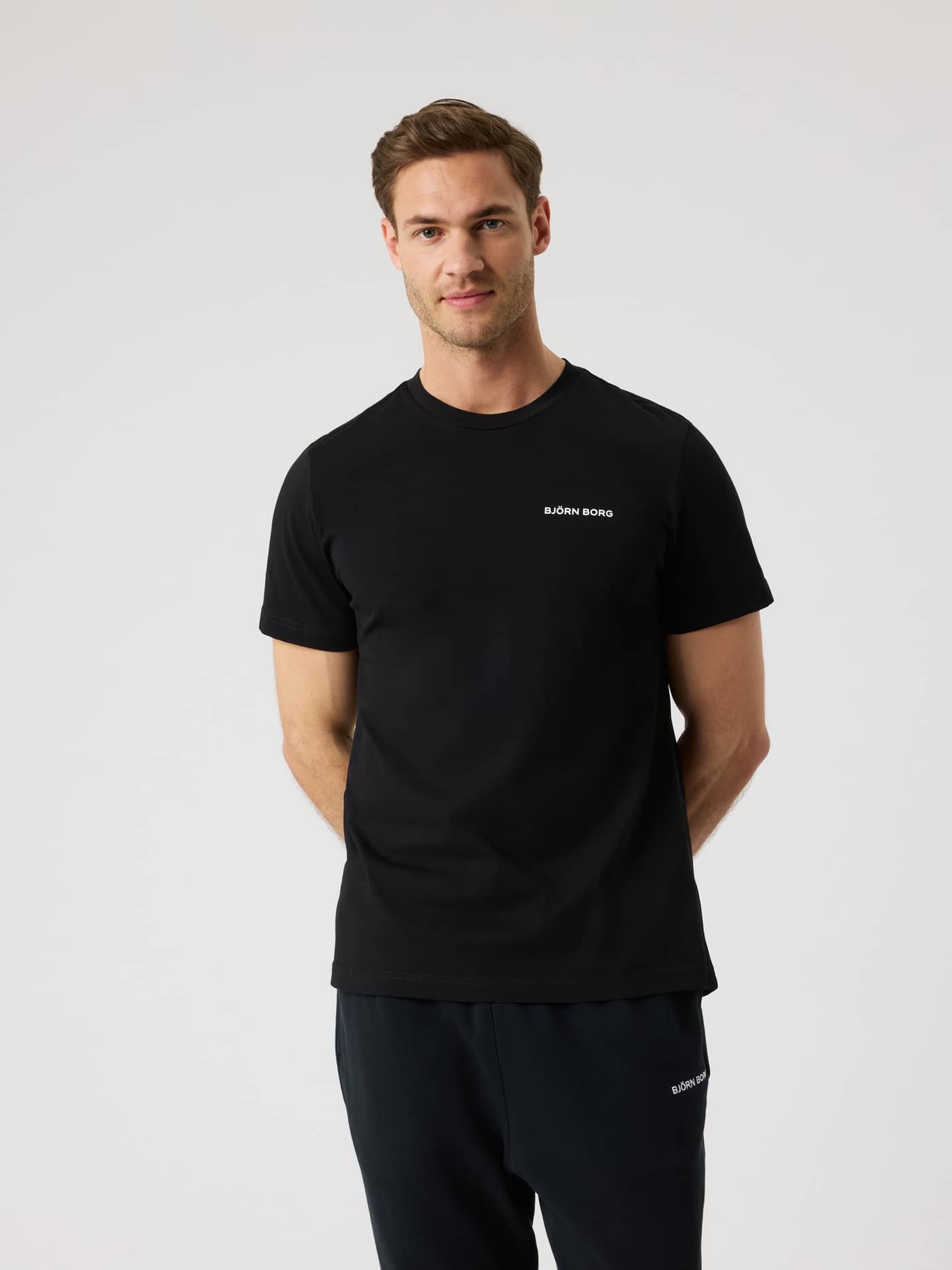 Vue de face d'un homme portant le Borg Sports T-Shirt en Black Beauty (Noir) avec un logo blanc pour l'entraînement. - Image 1