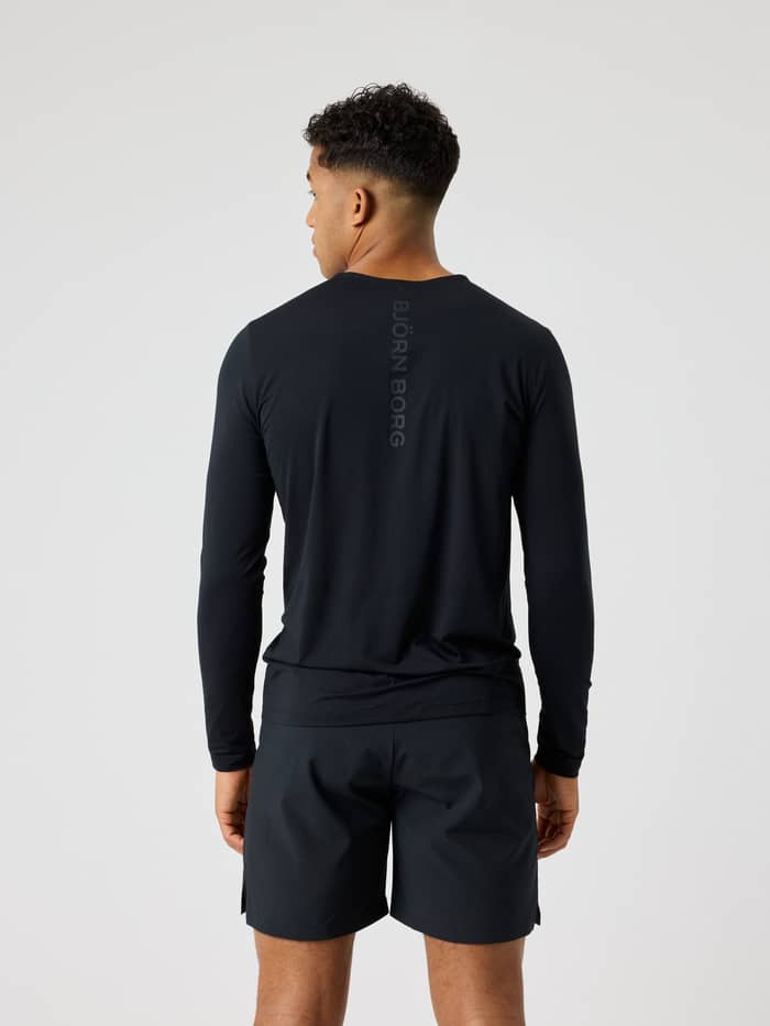 Man in achteraanzicht in Borg Feather Long Sleeve T-Shirt in Black Beauty (Zwart) met zwart logo voor training en tennis. - Image 2