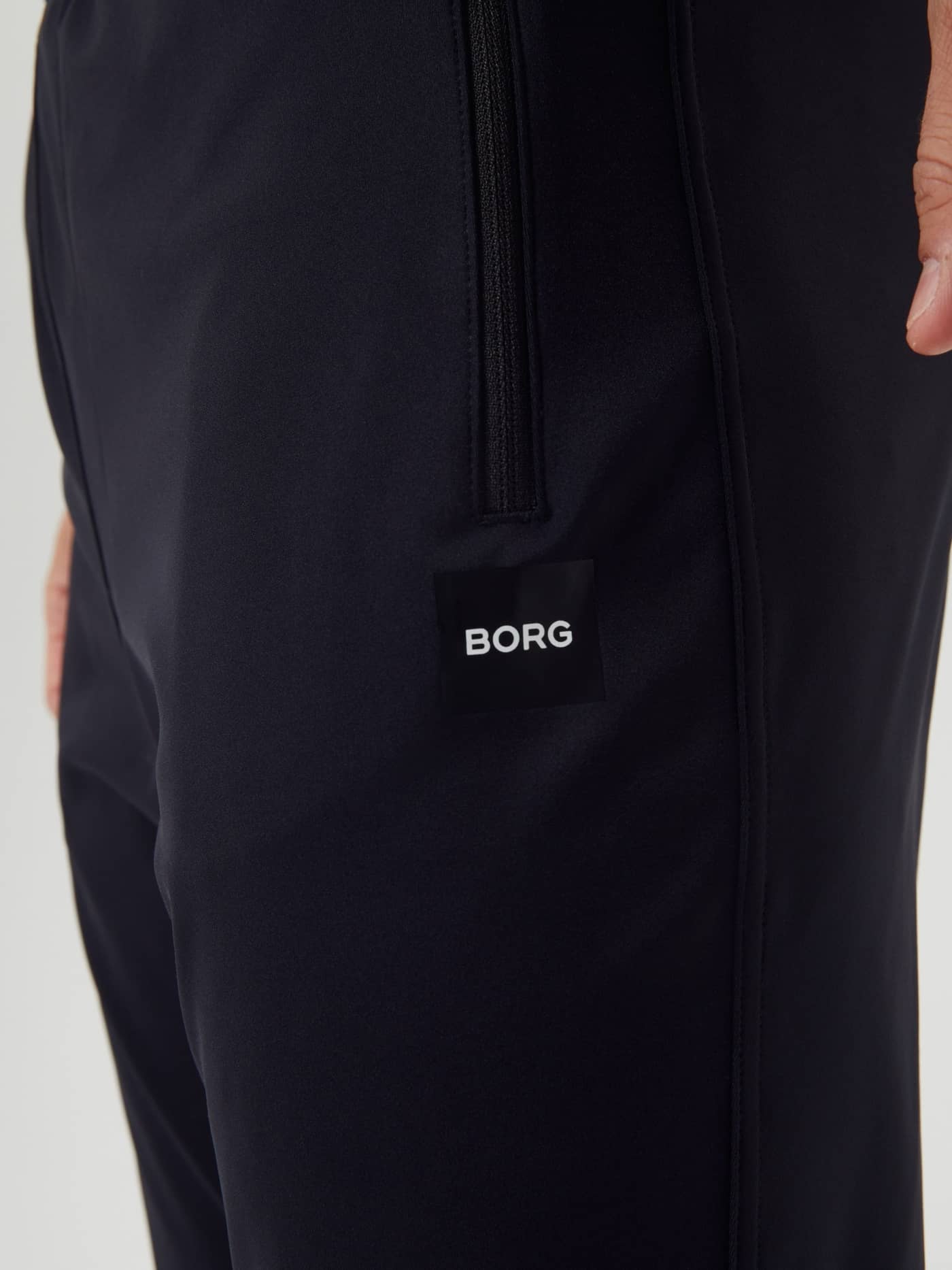 Funktionelle Reißverschlusstasche und weißes BORG-Logo an den Ace Training Pants in Black Beauty (Schwarz) für Tennis. - Image 3