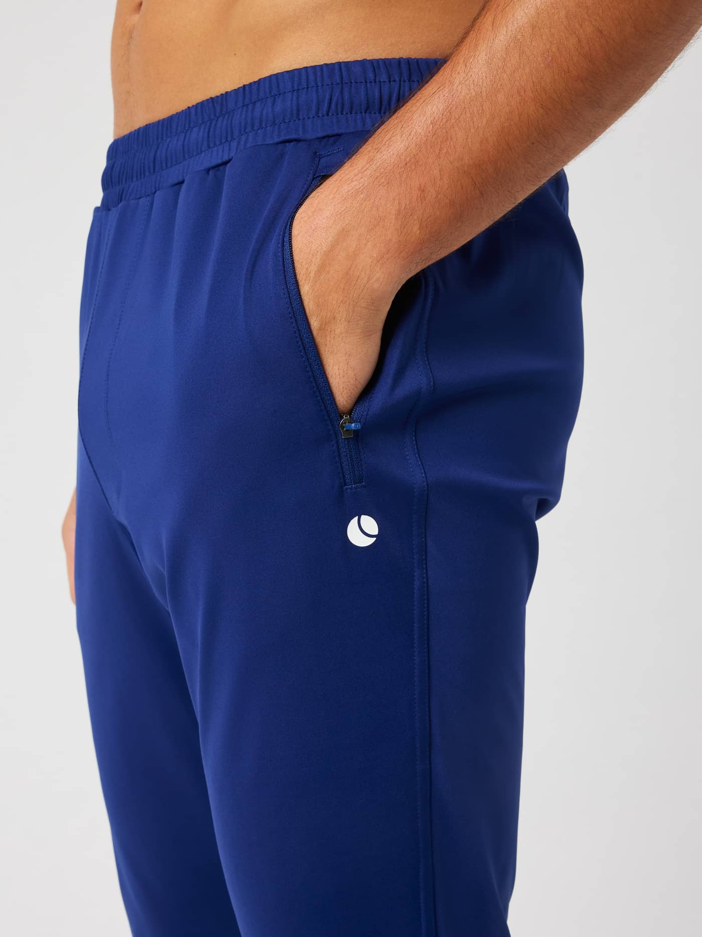 Seitenansicht der Ace Training Pants in Blue Depths (Blau) für Herren mit Reißverschlusstasche und weißem Tennis-Logo. - Image 4