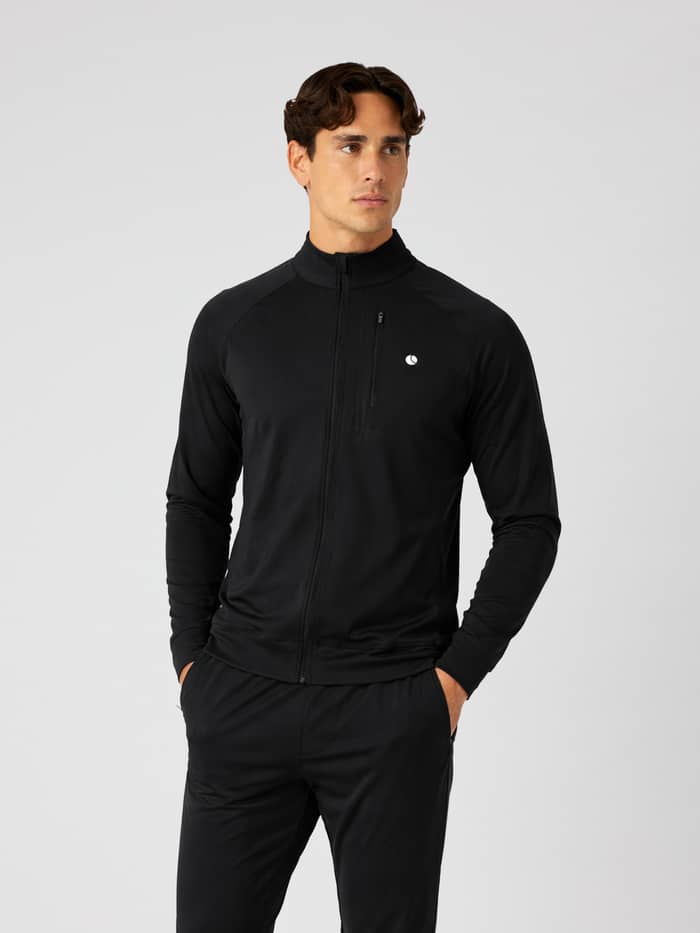 Front view of a man in the Björn Borg Ace Training Jacket in Black Beauty (Black) with a white logo for training and tennis.