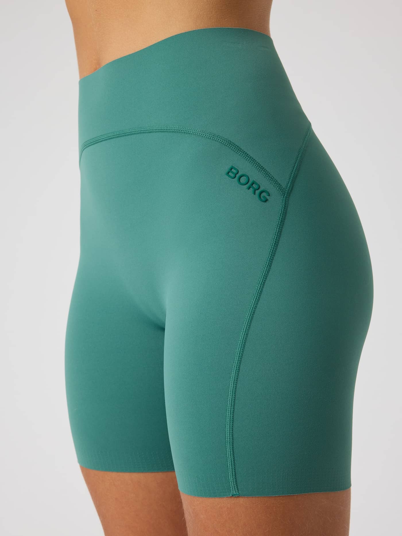 Close-up of Mallard Green (Green) Borg Sleek Shorts, featuring a green logo and a high-waist fit for performance training. - Image 4