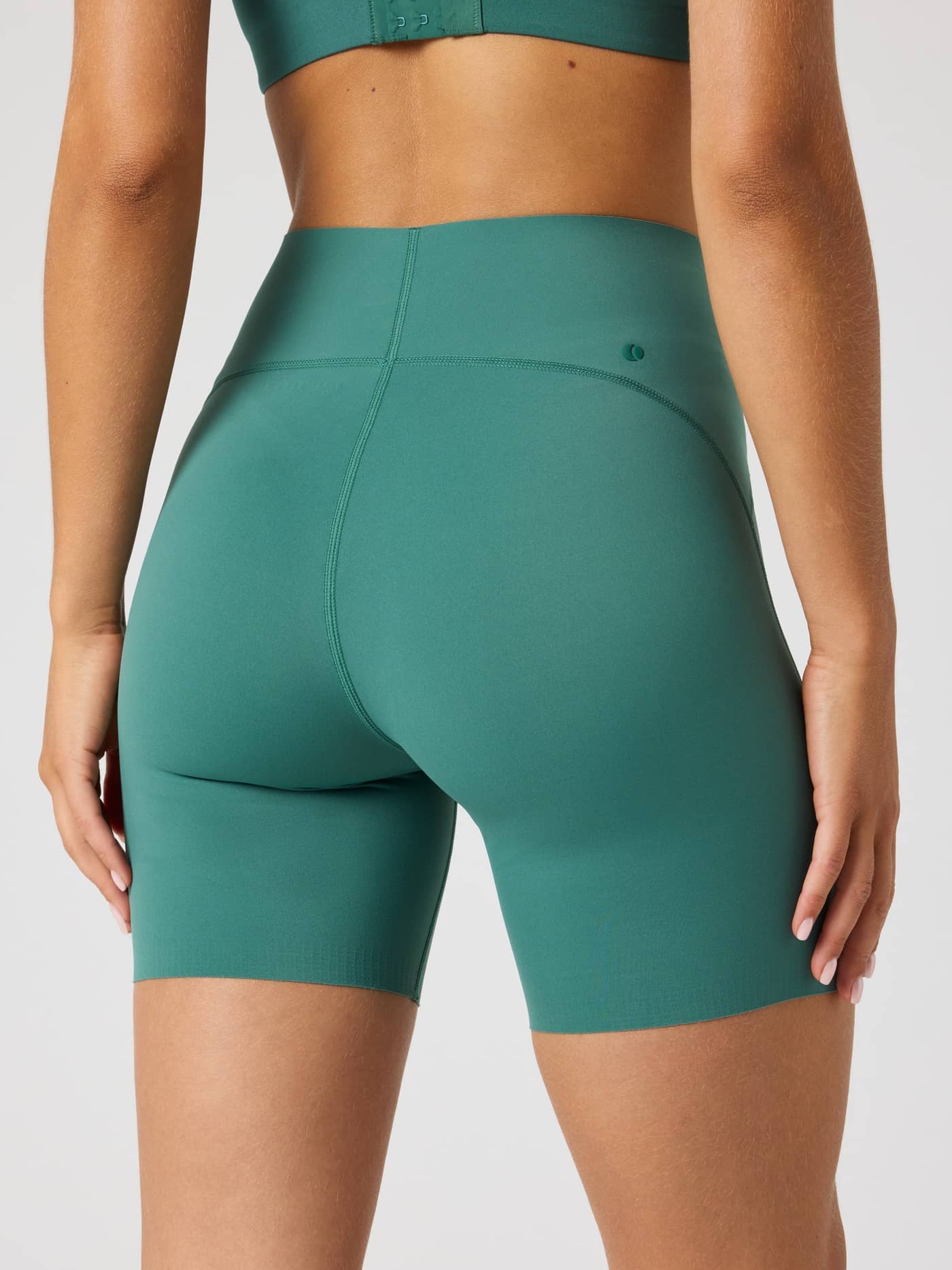Back view close-up of a model wearing high-waisted Björn Borg Sleek Shorts in Mallard Green (Green) for training. - Image 2