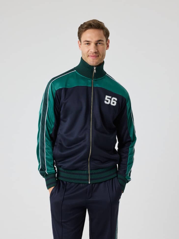 Front view of a man wearing the Björn Borg Ace Retro Track Jacket 56 in Night sky (Navy), a functional, striped tennis layer. - Image 3
