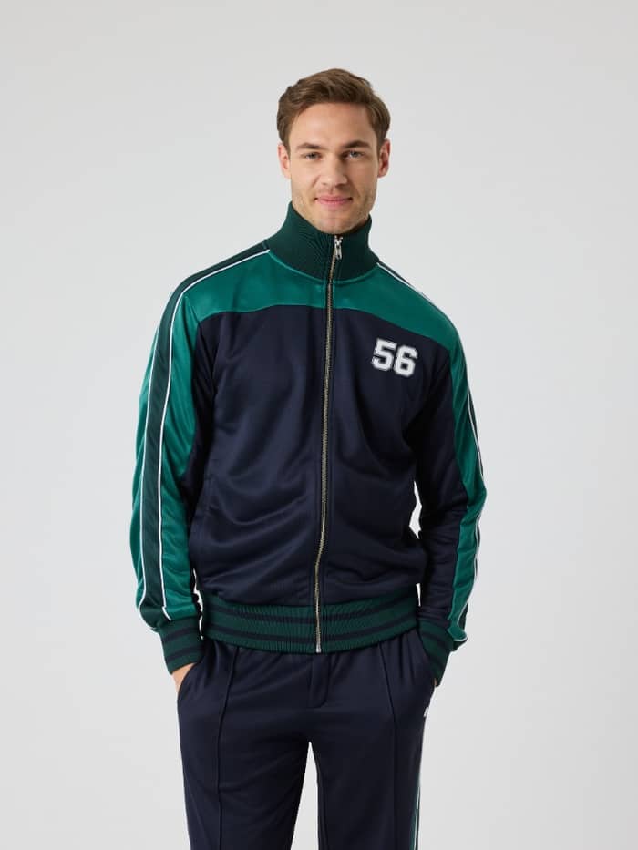 Front view of a man wearing the Björn Borg Ace Retro Track Jacket 56 in Night sky (Navy), a functional, striped tennis layer. - Image 3