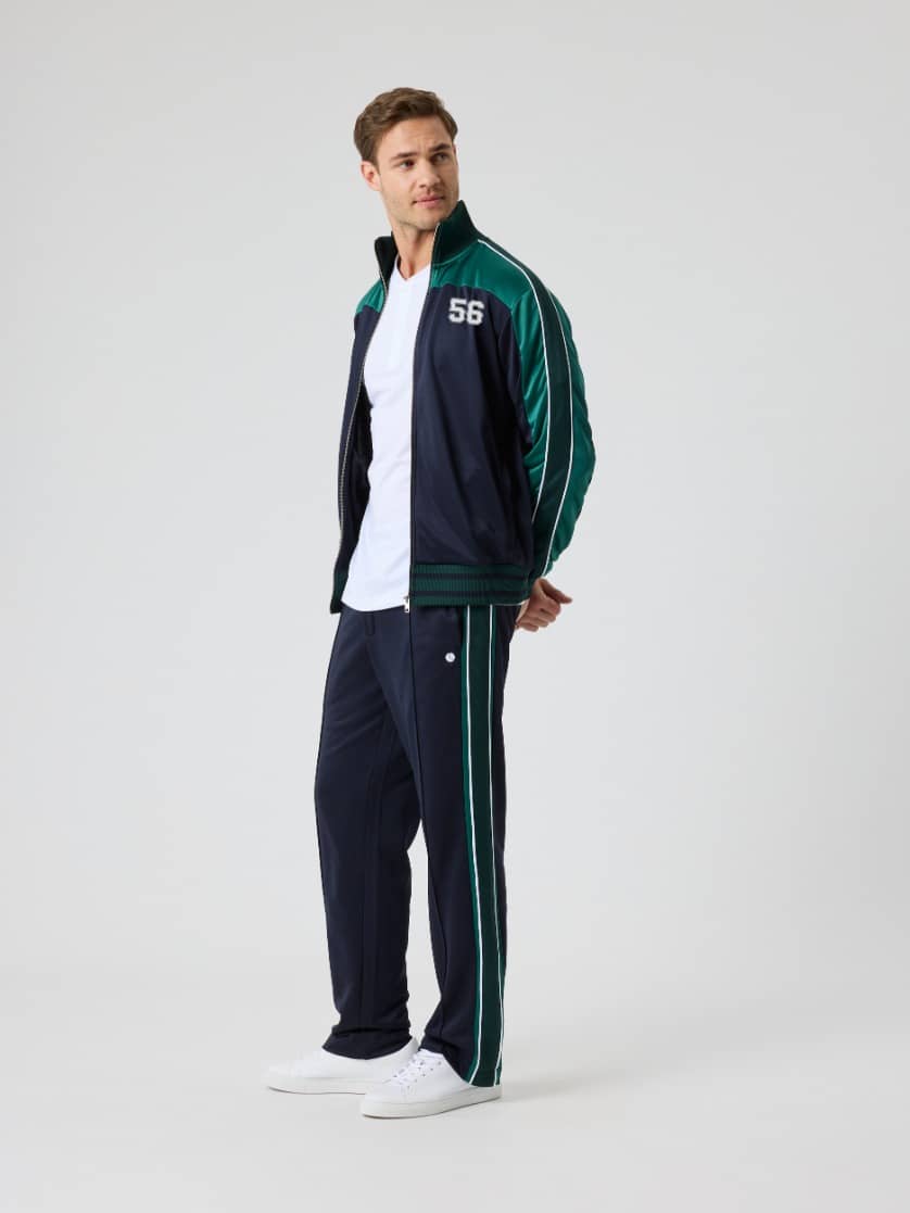Full-body side view of a man in the Björn Borg Ace Retro Track Jacket 56 in Night Sky (Navy) for tennis performance. - Image 4