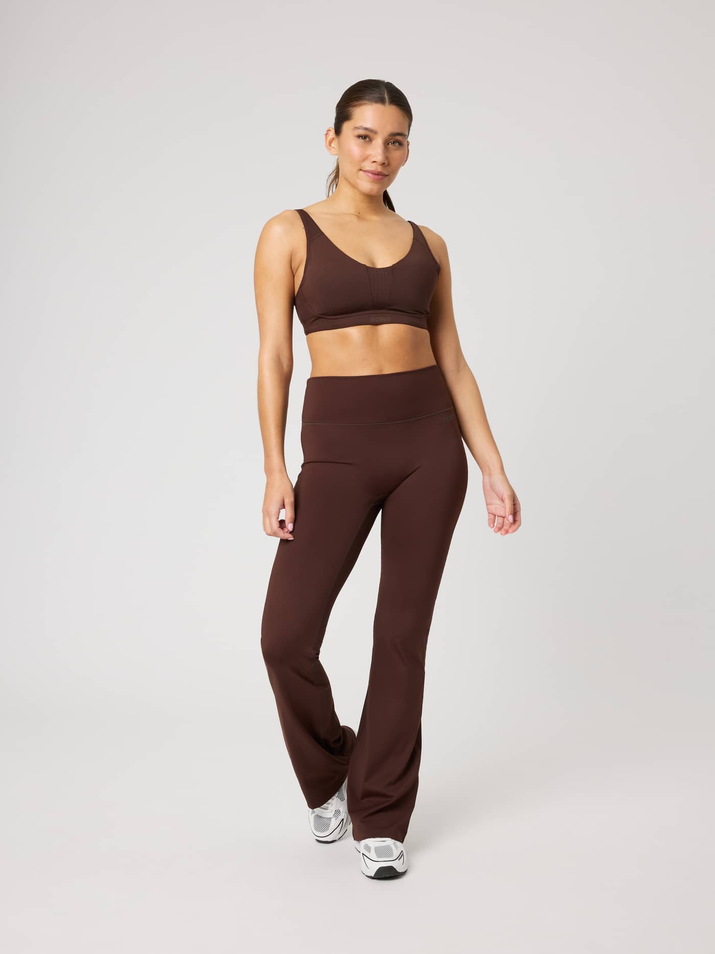 Borg Flare Tights Regular in Coffee Bean (Brown) worn by a model in a full-body front view for a stylish training look. - Image 3