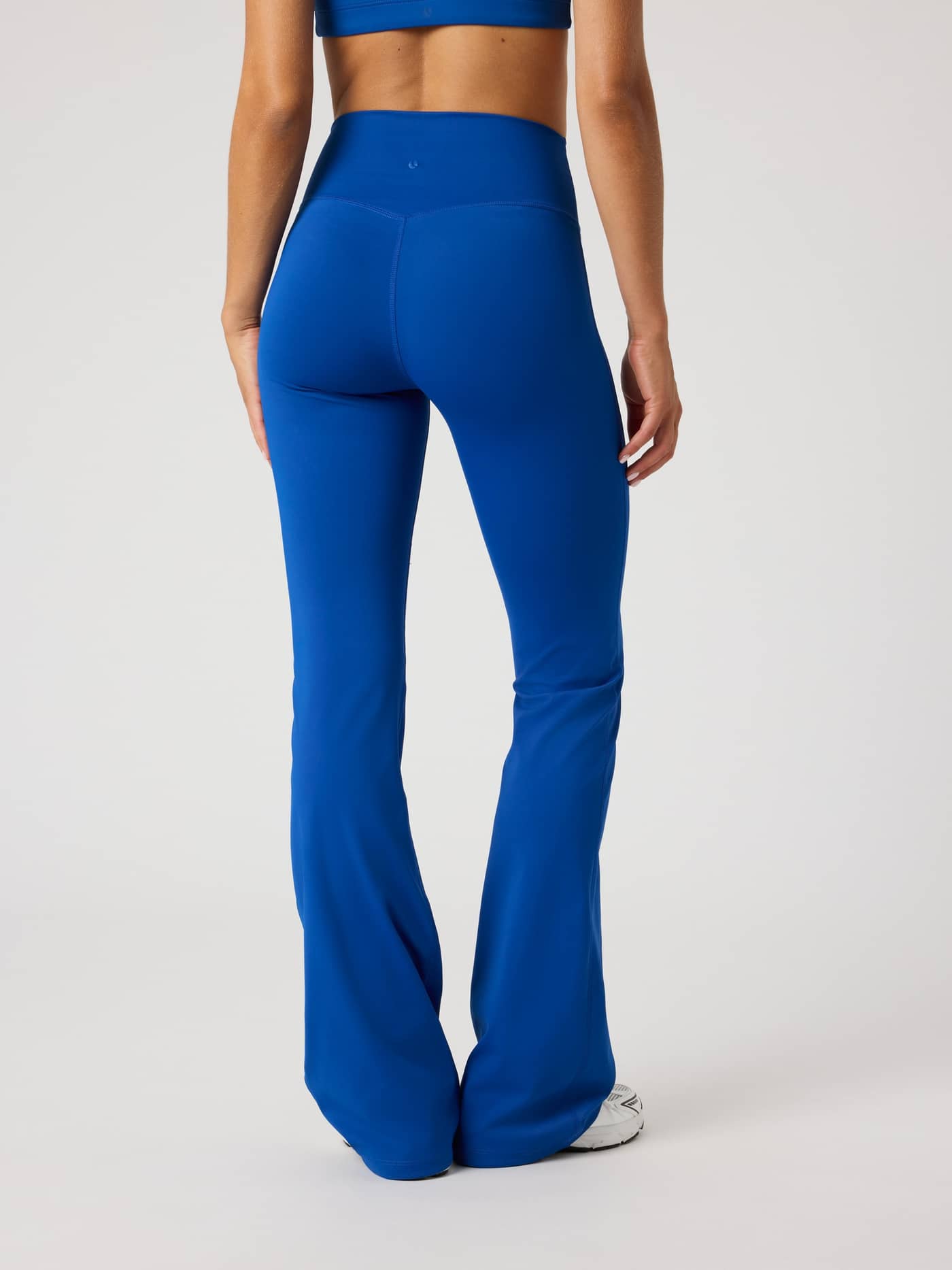 Back view of a model wearing high-waisted Borg Flare Tights Regular in Monaco Blue (Blue) for training. - Image 2