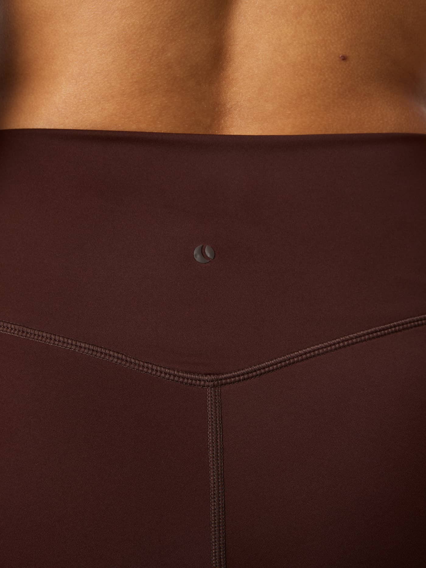 Back waist view of Borg Flare Tights Regular in Coffee Bean (Brown) showing a dark tennis ball print logo for training. - Image 4