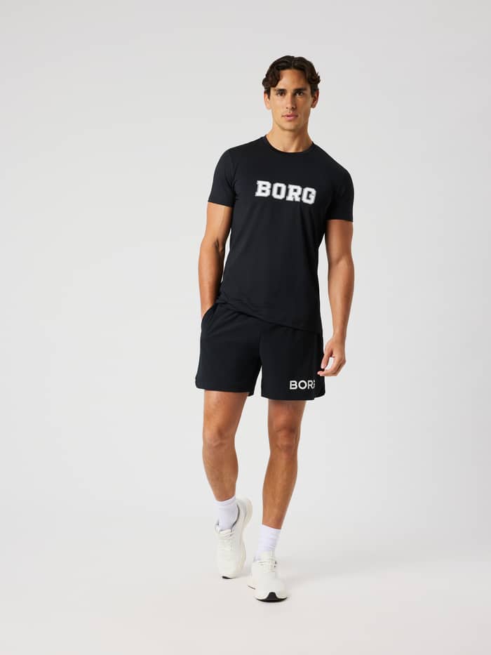 Vooraanzicht van een man in het functionele Borg Graphic T-Shirt in Black Beauty (Zwart) voor training en tennis. - Image 3