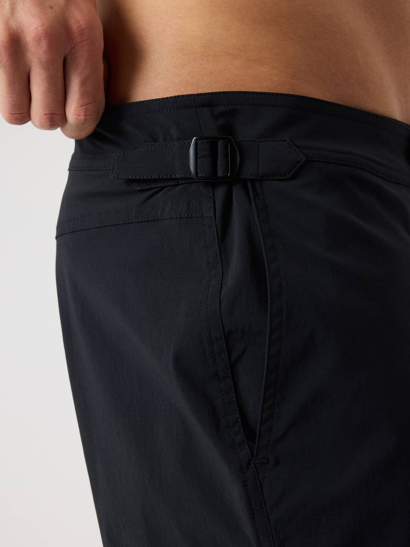 Close-up of the functional side buckle and pocket on the Borg Tailored Swim Shorts in Black Beauty (Black). - Image 5