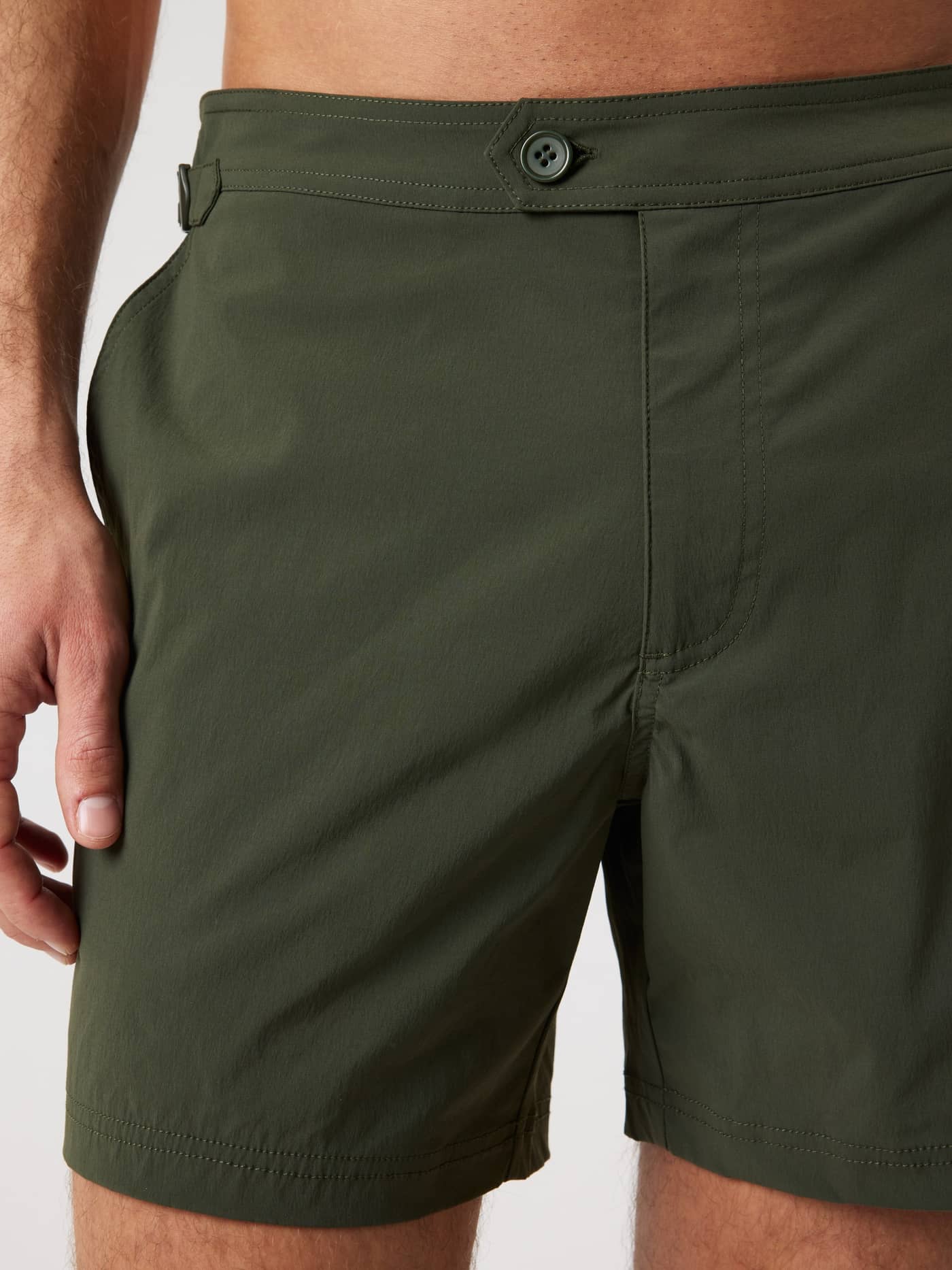 Close-up of the Borg Tailored Swim Shorts in Forest Night (Green) with button closure and adjustable side buckle. - Image 6