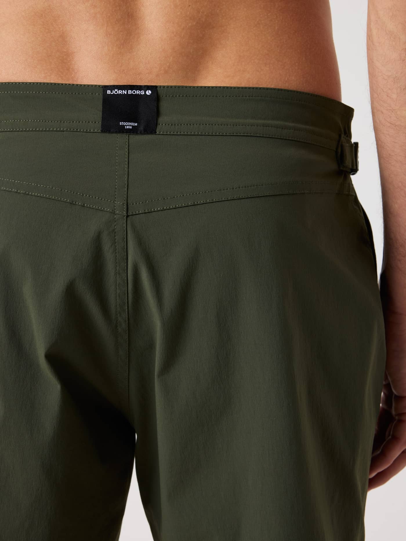 Back view of the Borg Tailored Swim Shorts in Forest Night (Green) featuring a black logo label and side buckles. - Image 4