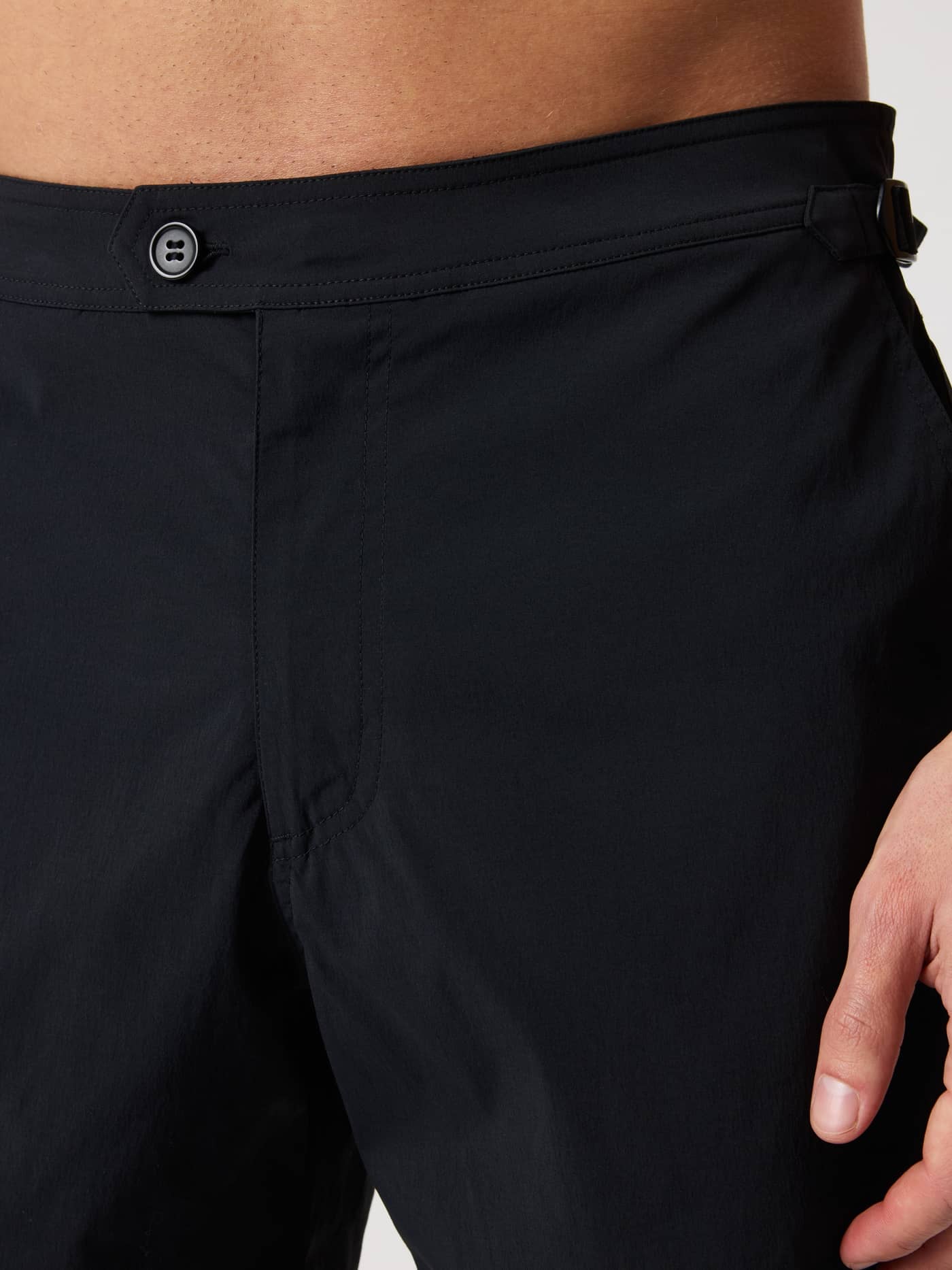 Detailed close-up of the black Borg Tailored Swim Shorts, highlighting the button closure and adjustable side buckles. - Image 6