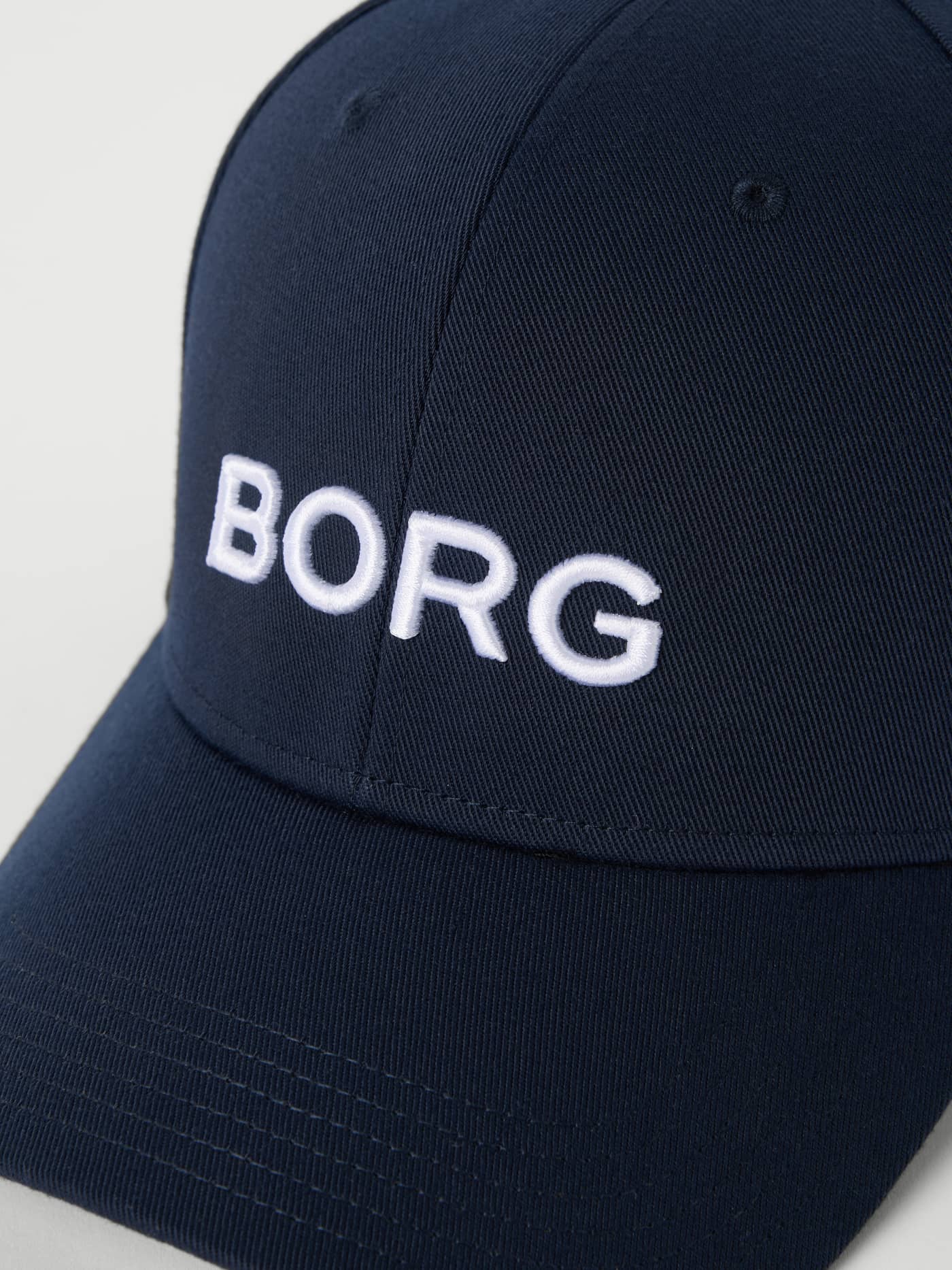Detailed close-up of the polyester Borg Baseball Cap in Night sky (Navy), with an embroidered BORG logo for tennis. - Image 3