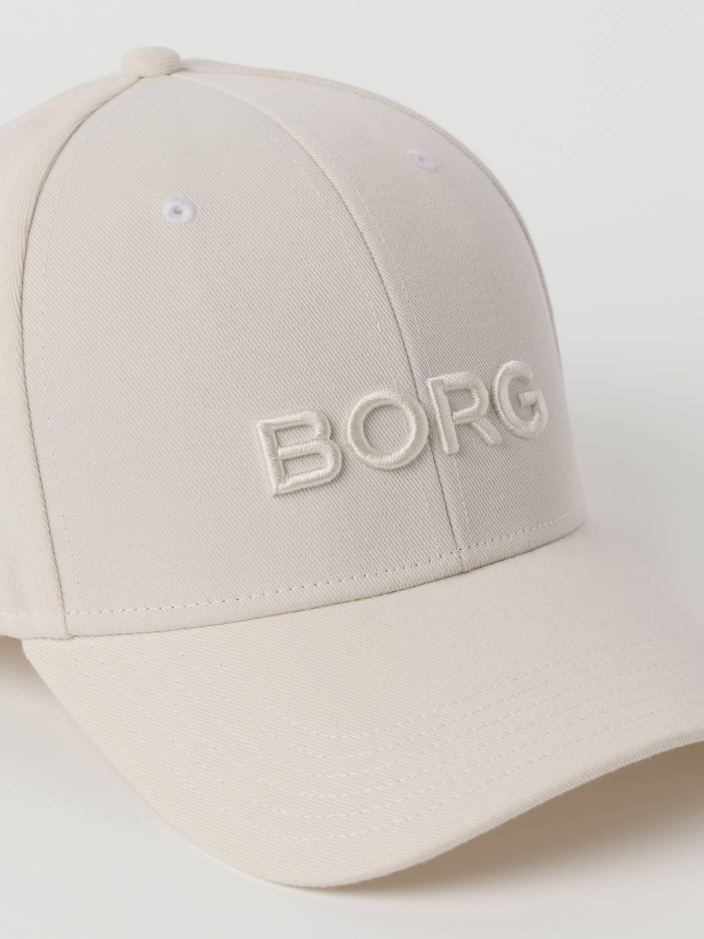 Detailed close-up of the Borg Baseball Cap in Tofu (White), highlighting the embossed logo and sporty tennis style. - Image 3