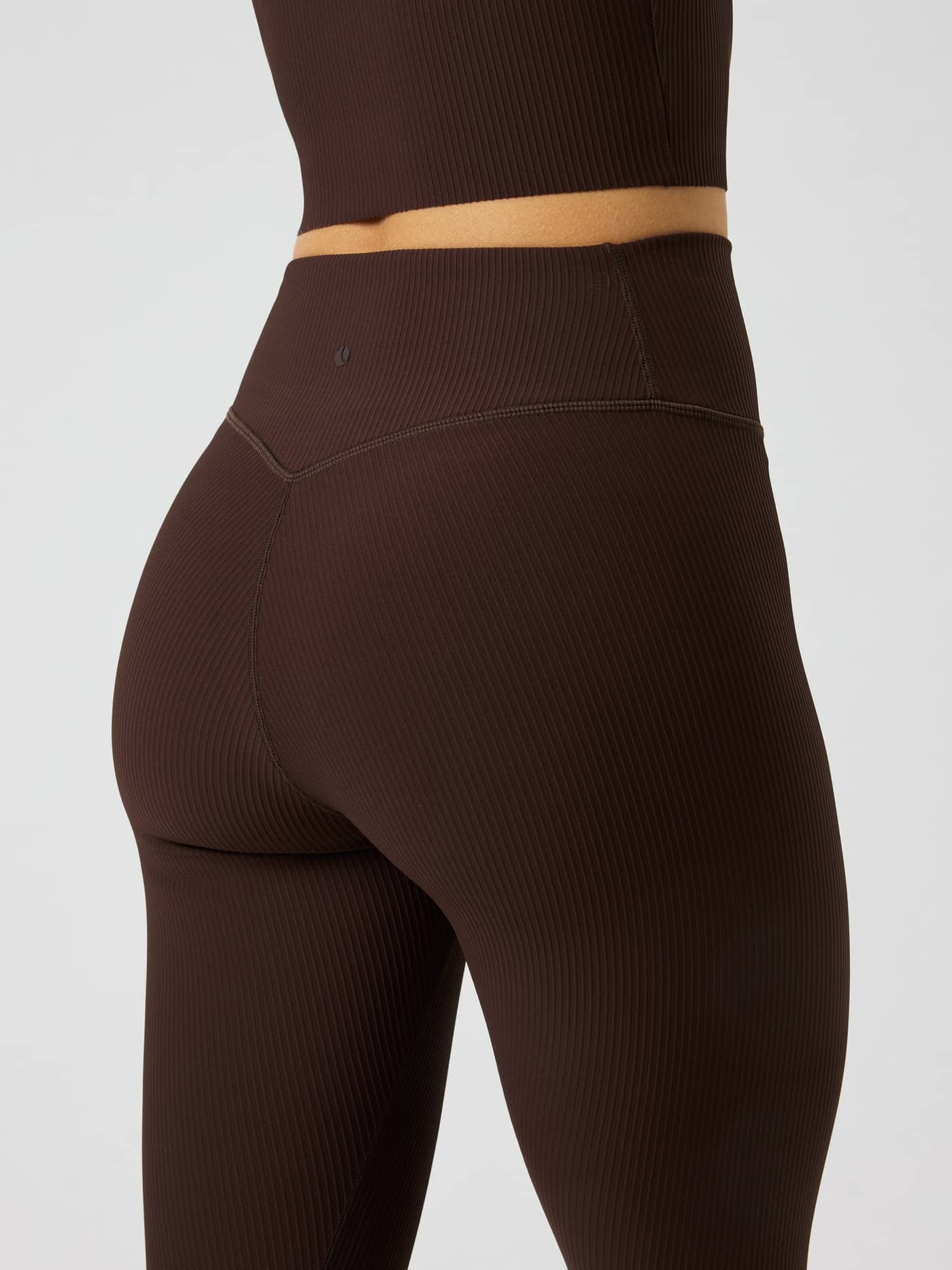 Back view of Studio Ribbed Tights in Coffee Bean (Brown) showing the textured rib and black logo for training support. - Image 4