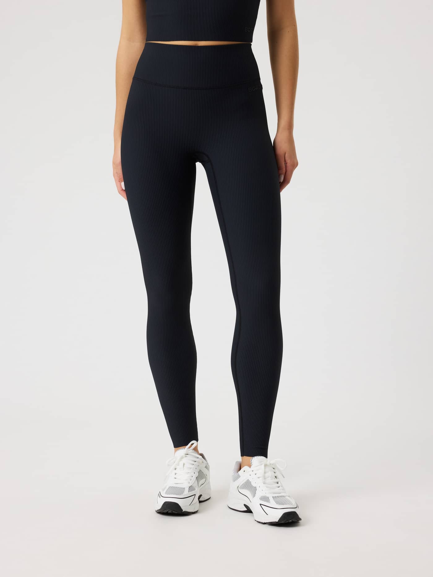 Front view of a model wearing high-waisted Studio Ribbed Tights in Black Beauty (Black) featuring a textured training fit. - Image 2