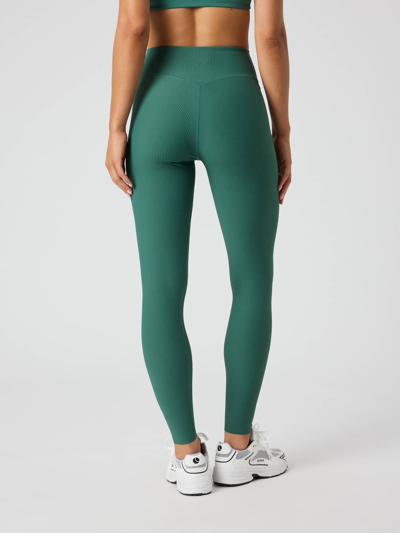Back view of a woman wearing the Studio Ribbed Tights in Mallard Green (Green) for performance training. - Image 2