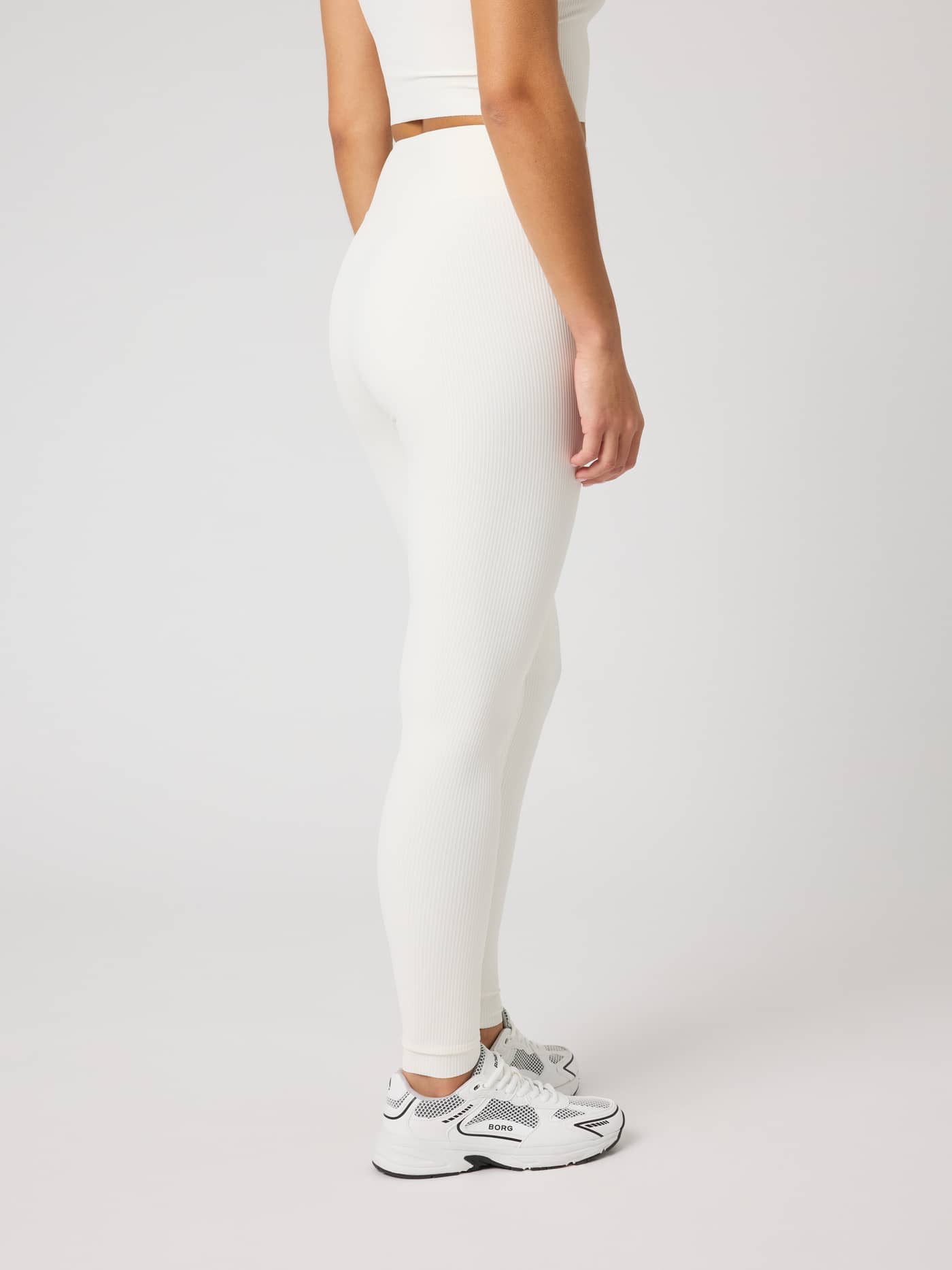 Side view of the Studio Ribbed Tights in Tofu (White) featuring a textured ribbed design for training. - Image 3