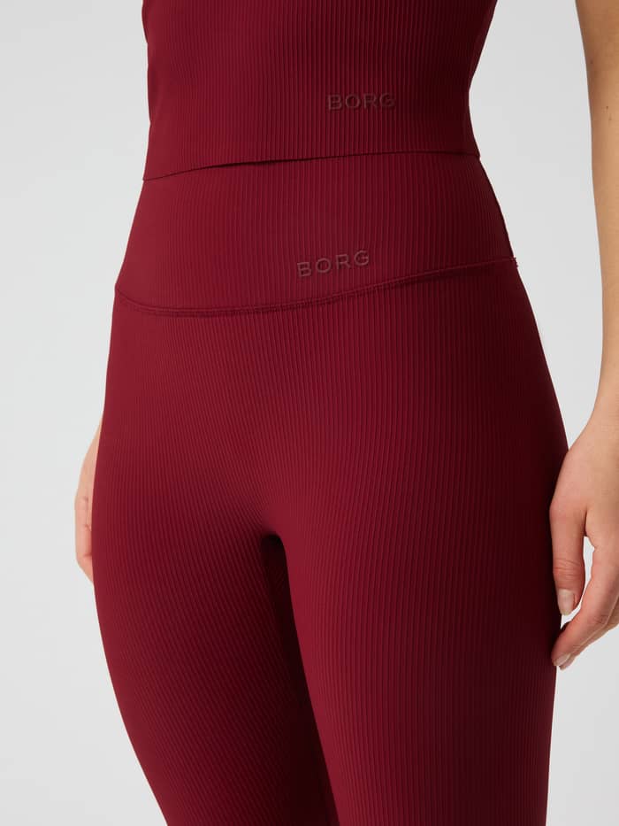 Close-up of the Studio Ribbed Tights in Cabernet (Red) featuring a high waist design and the Borg logo.