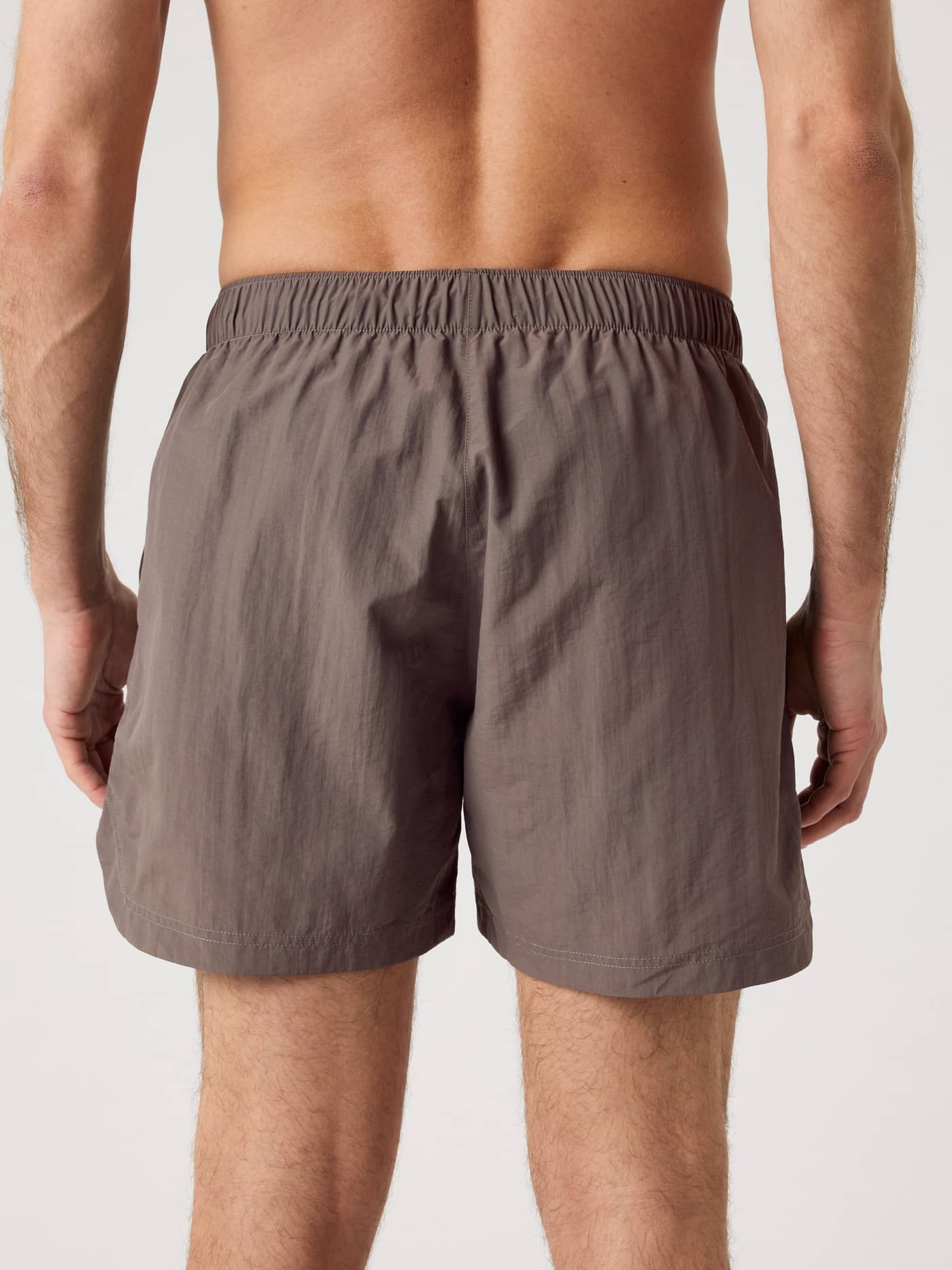 Back view of a man wearing the Borg Gym Shorts 5 Inch in Falcon (Brown), providing style and function for training. - Image 2