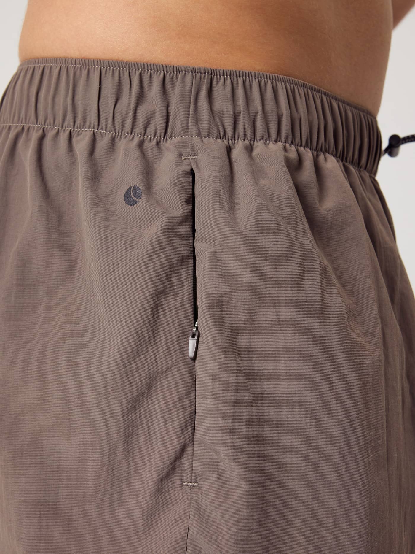 Side close-up of the Borg Gym Shorts 5 Inch in Falcon (Brown) featuring a functional zipper pocket for training. - Image 3