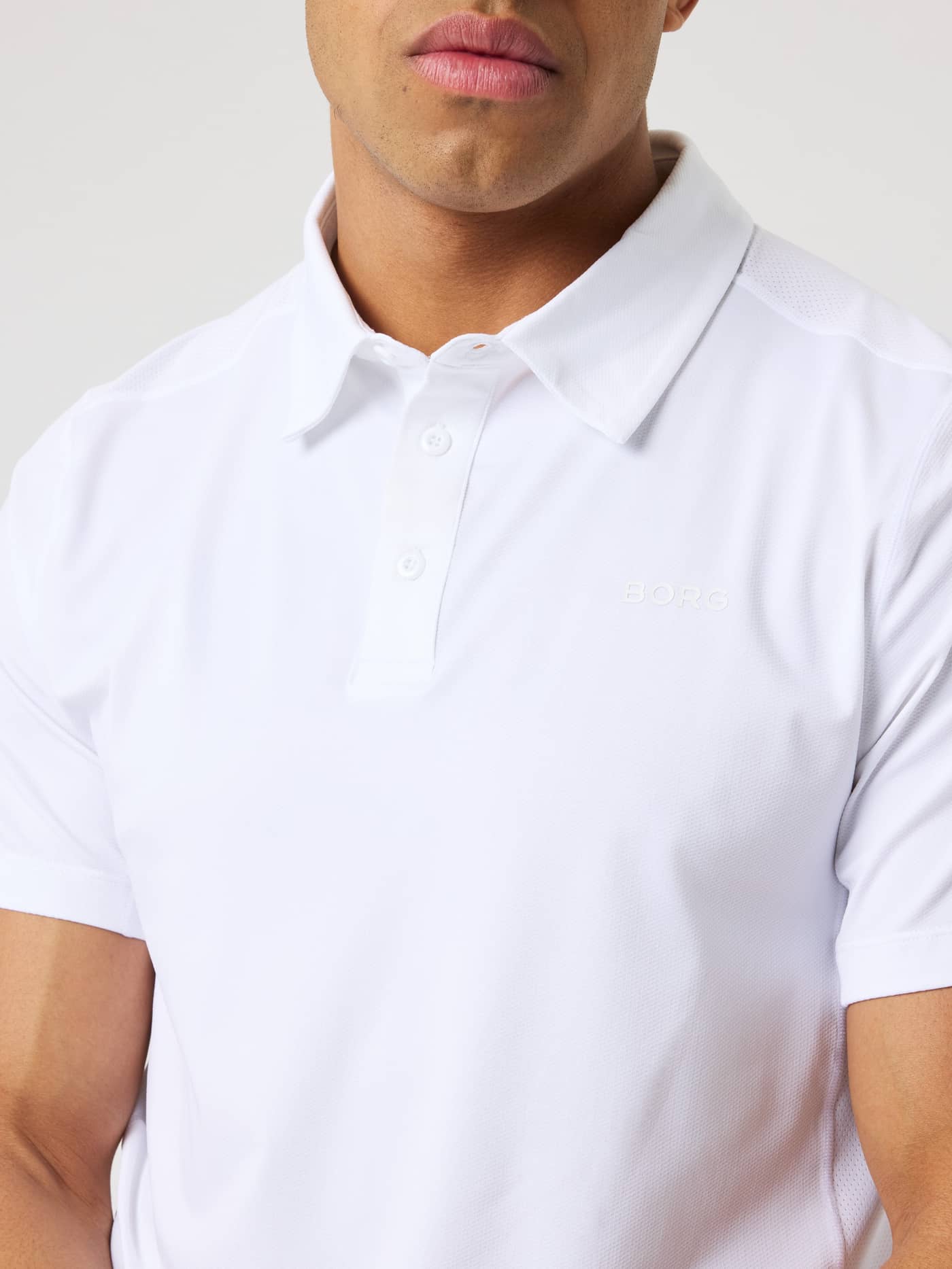 Nærbillede af Borg Sports Polo Shirt i Brilliant White (Hvid) med hvidt BORG-logo, ideel til tennis. - Image 4