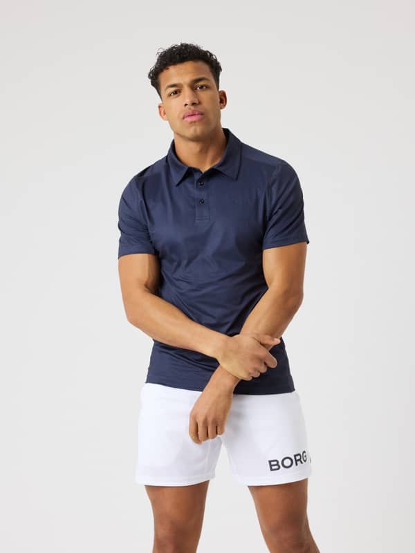 Modell framifrån i Night sky (Marinblå) Borg Sports Polo Shirt, designad för stil och funktion inom tennis.