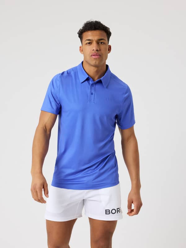 Framifrån på en man i Borg Sports Polo Shirt i Amparo Blue (Blå) med snabbtorkande mesh för tennis.