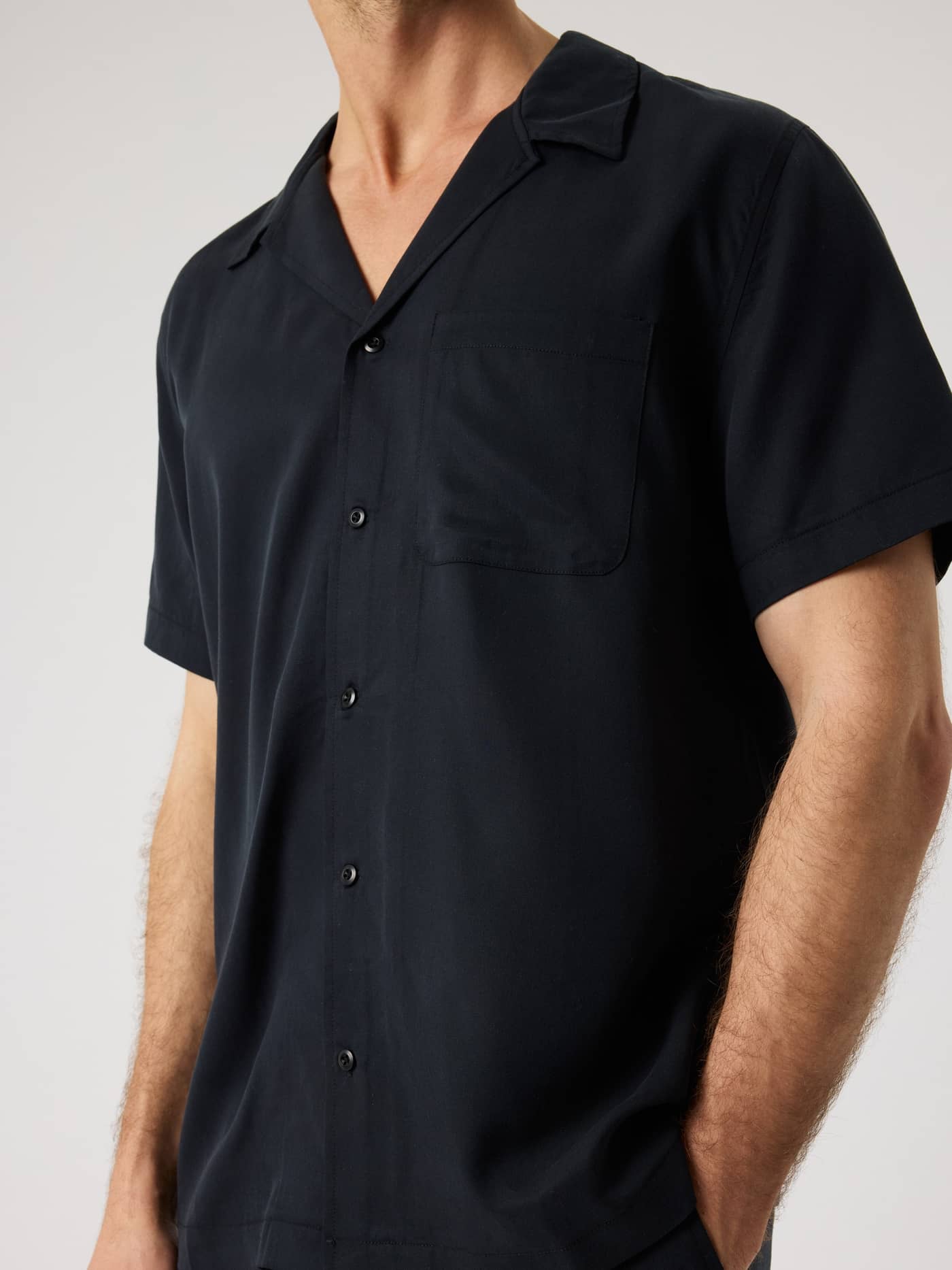 Close-up of a man wearing the Borg Lyocell Resort Shirt in Black Beauty (Black) with a camp collar and chest pocket. - Image 5