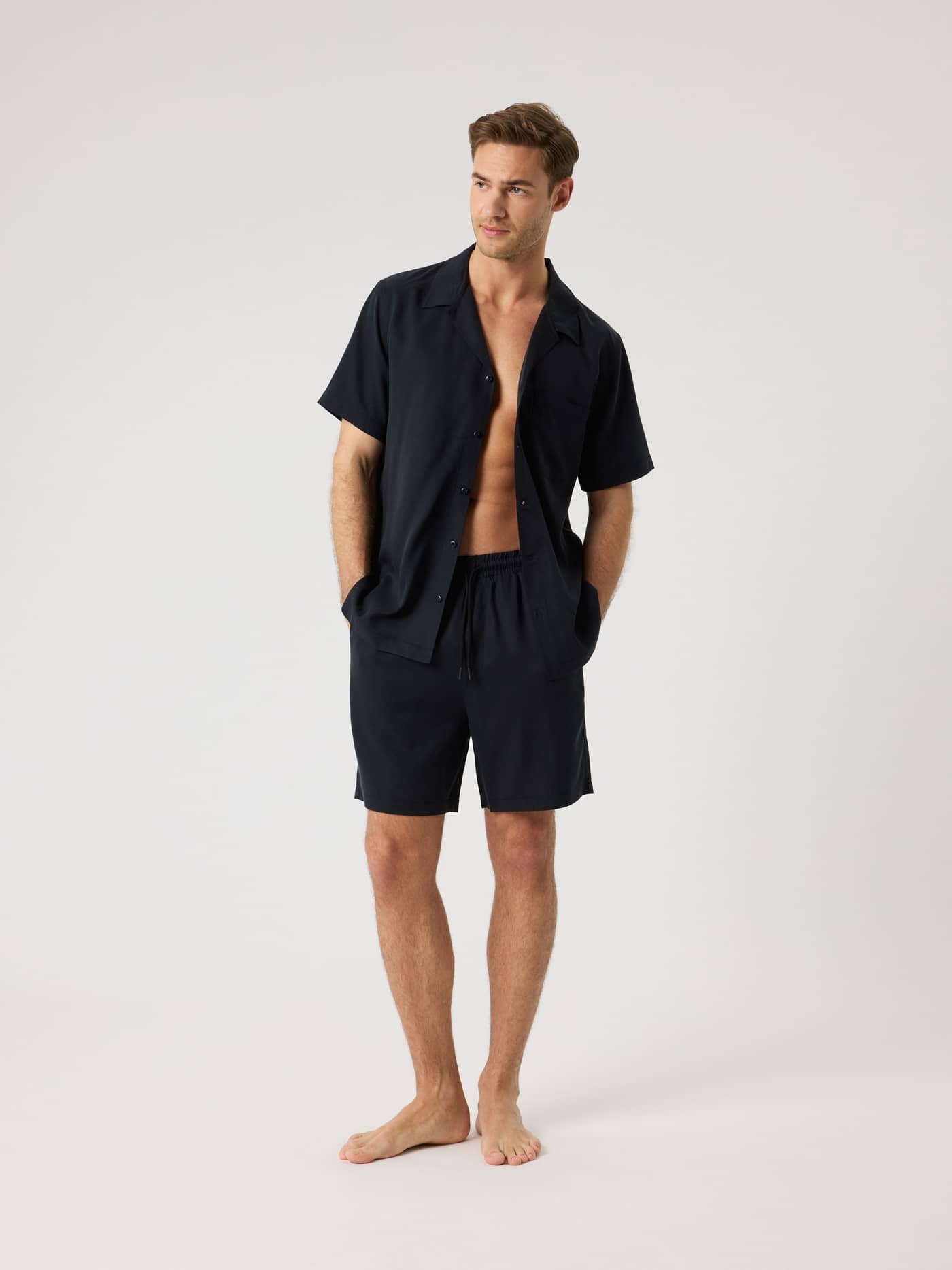 Full-body front view of a man in the Björn Borg Lyocell Resort Shirt in Black Beauty (Black), crafted from soft Lyocell. - Image 3