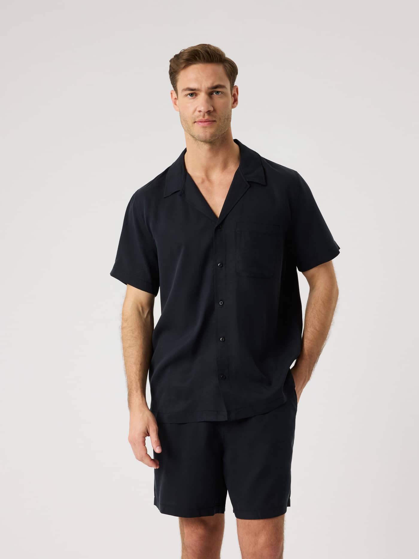 Vorderansicht eines Models im atmungsaktiven Borg Lyocell Resort Shirt in Black Beauty (Schwarz) mit Camp-Kragen. - Image 1